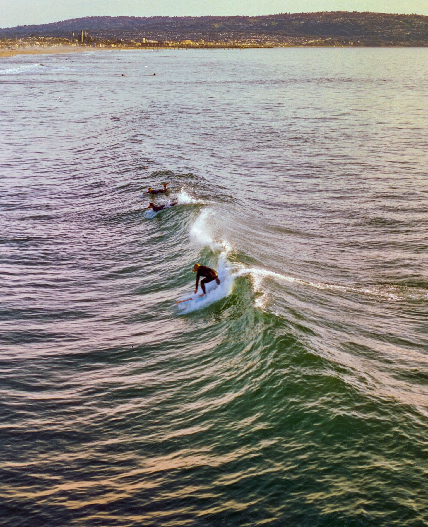 Surfers paddle swiftly through crashing waves seeking the perfect spot for a thrilling ride on their surfboards