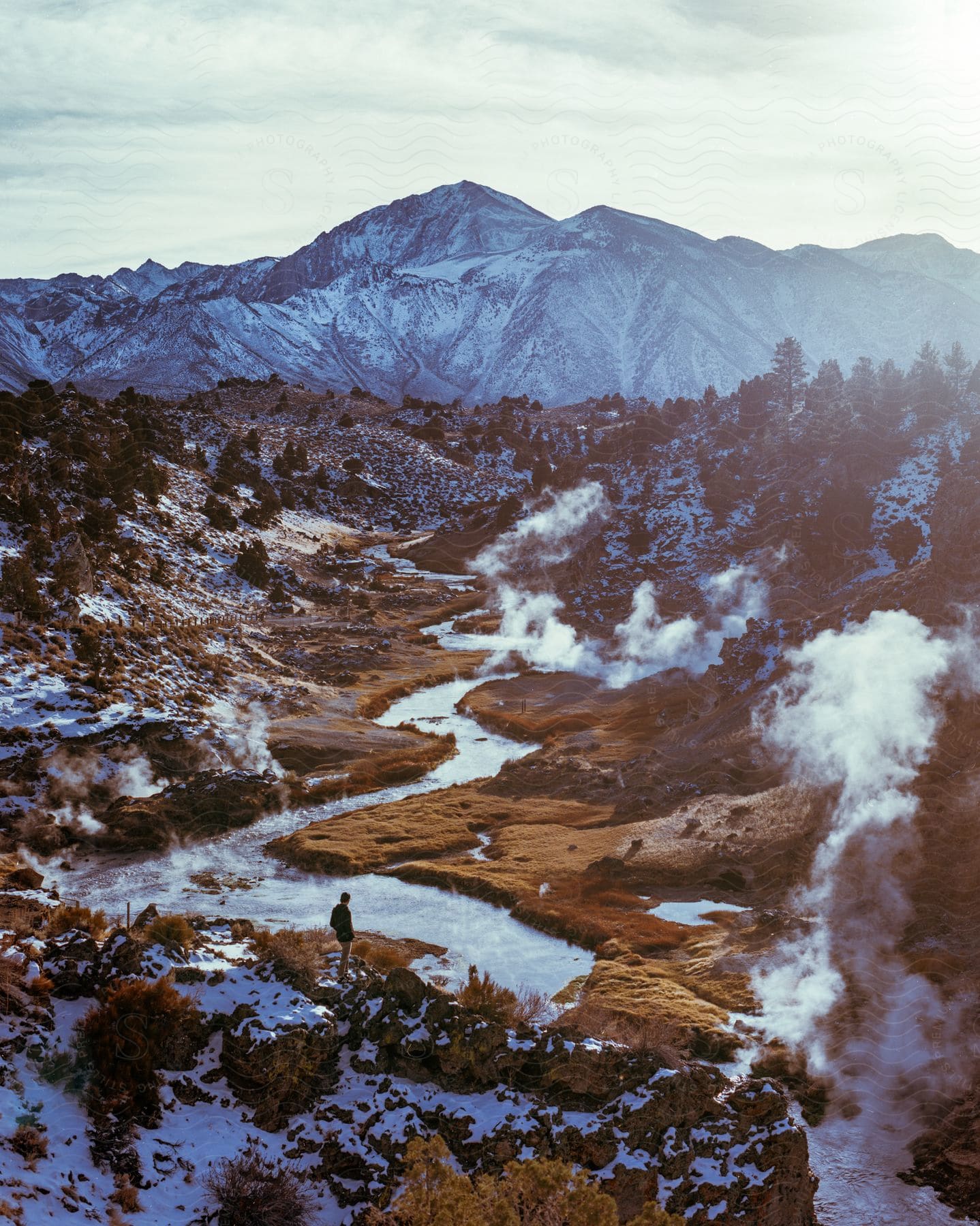 Stock photo of a distant man stands at hot creek geological site near mammoth lakes