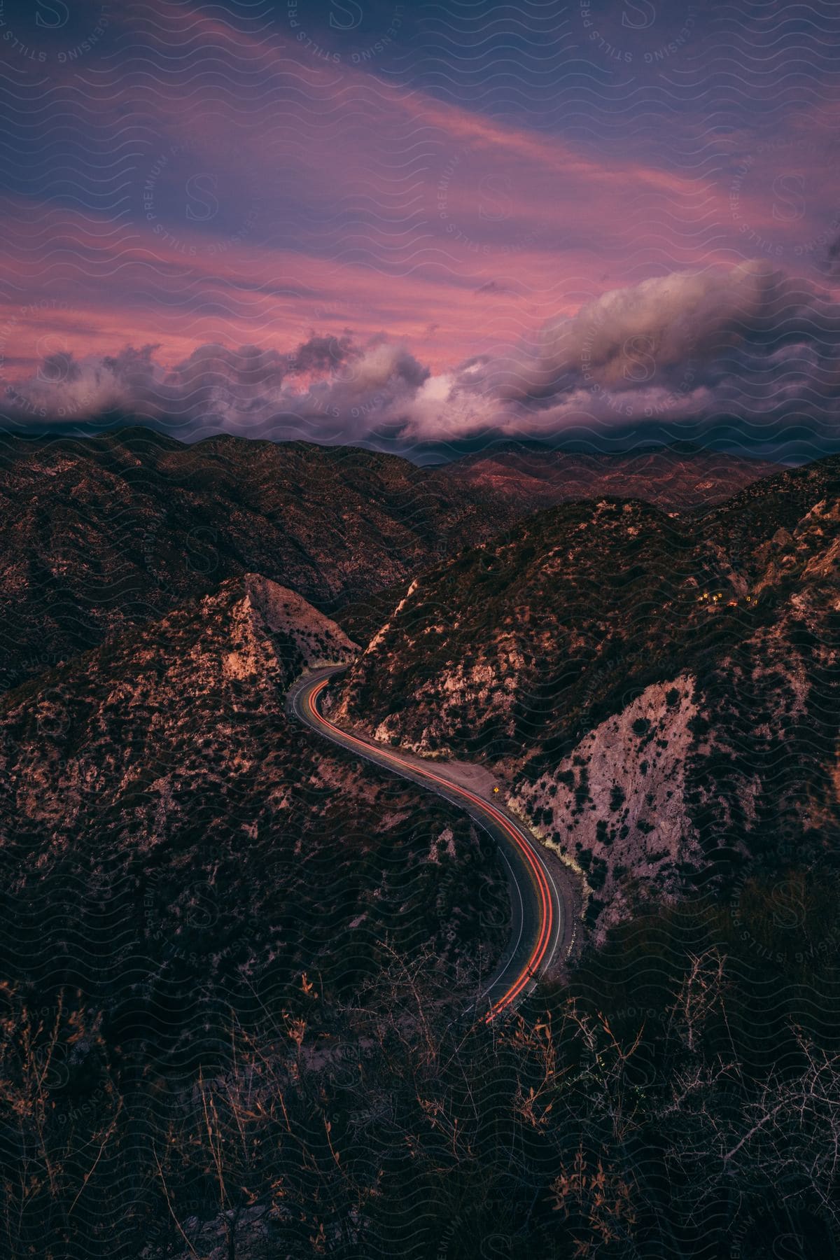 A mountain range at dusk on a cloudy day