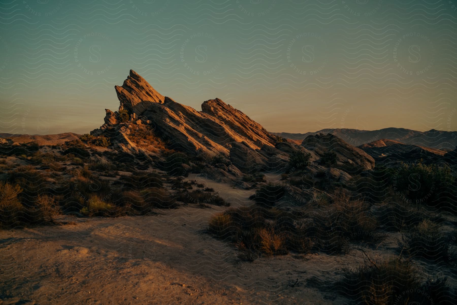 A mountain peak at dawn with vegetation on the ground