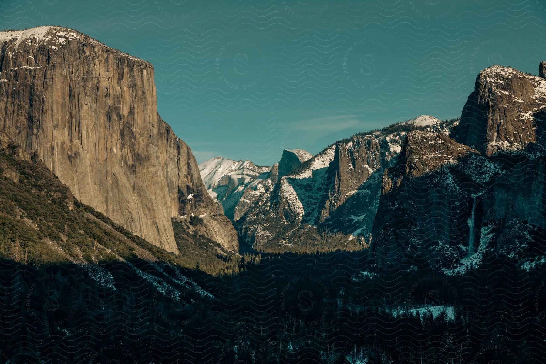 A serene mountain landscape with trees and a cloudy sky