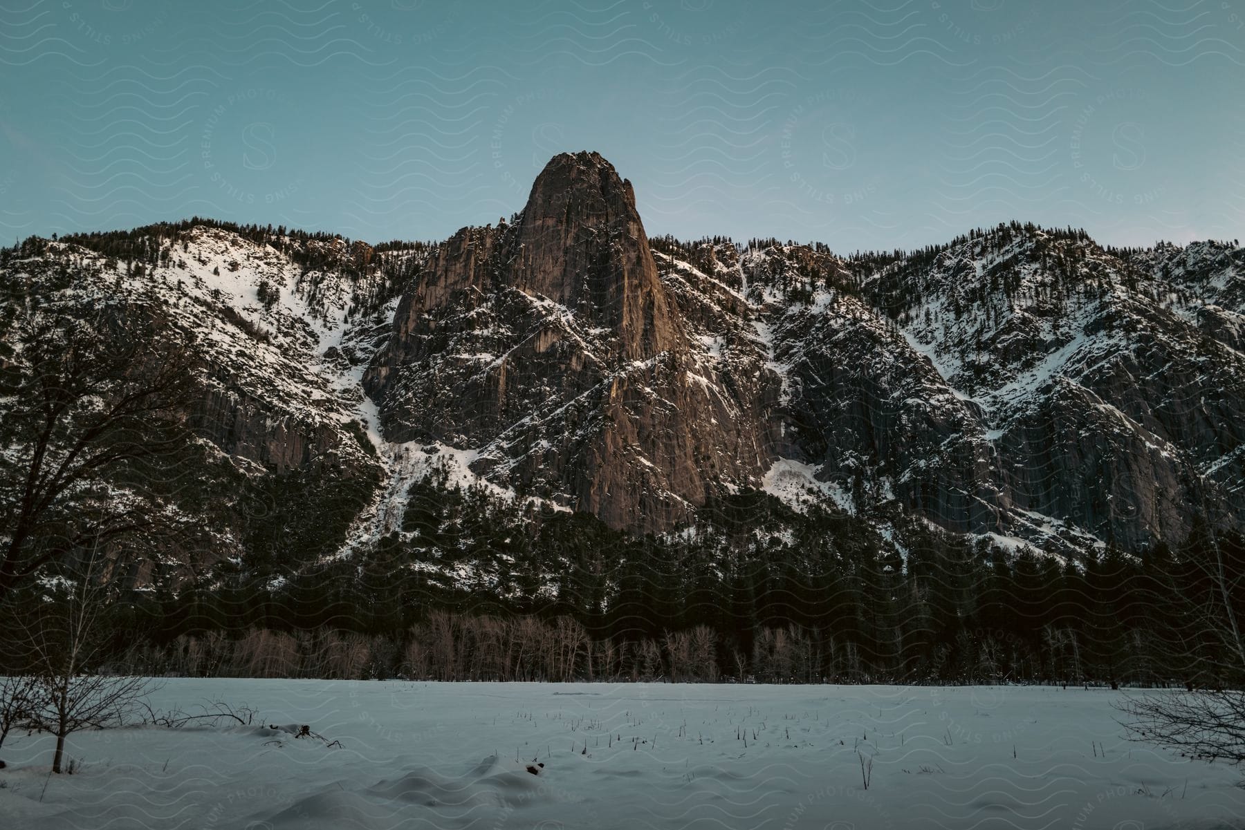 A serene mountain landscape with a frozen lake and snowy peaks