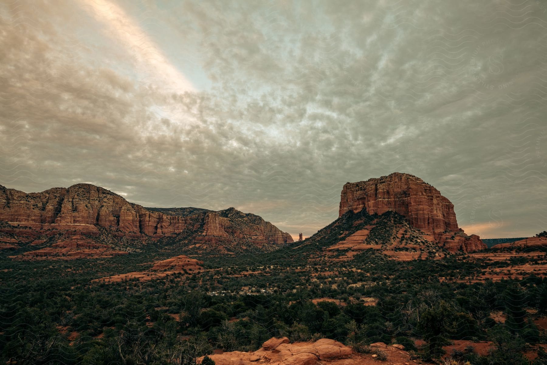 Rocky mountains with greenery and cloudy sunset