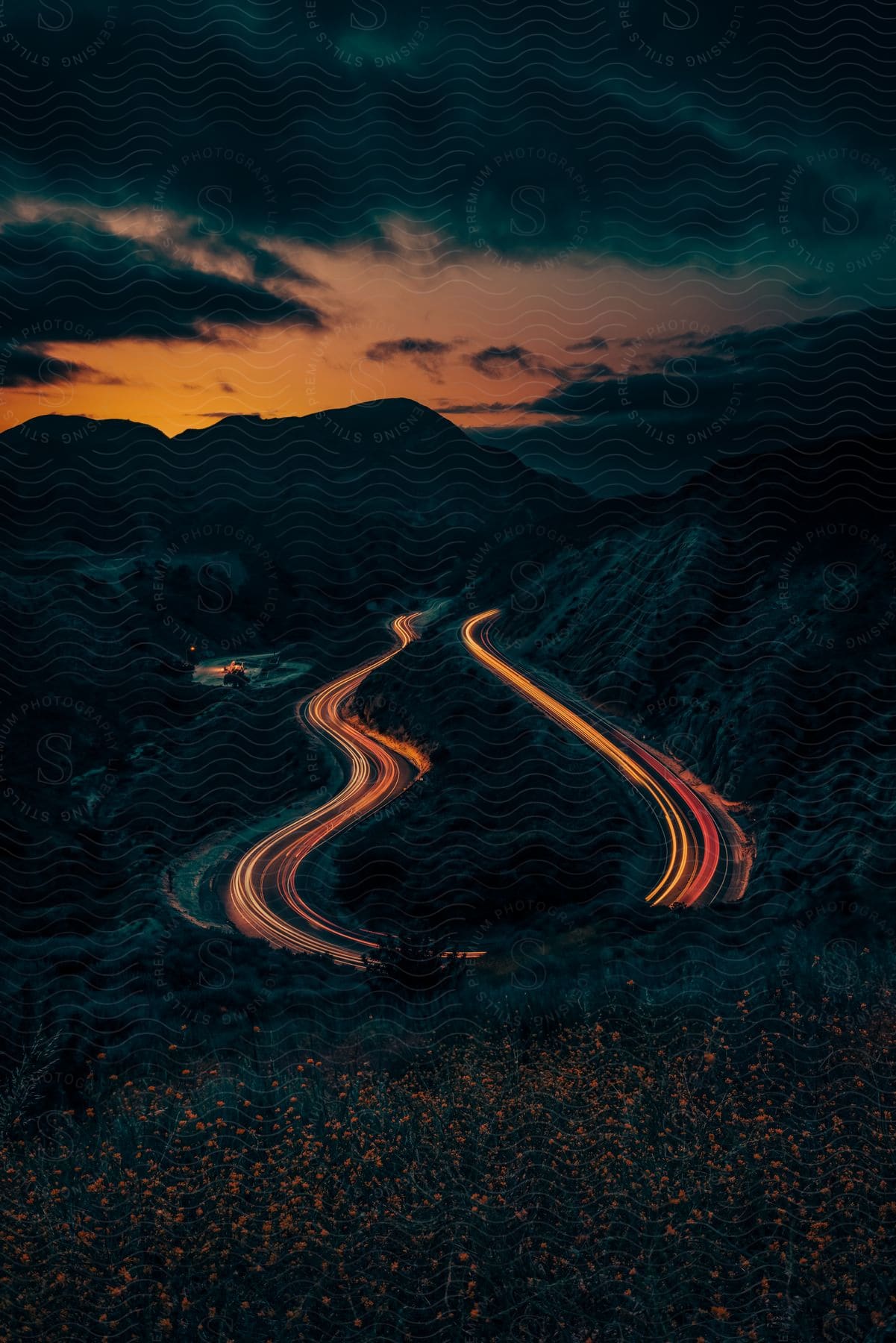 A mountain landscape at dusk with a road and sky