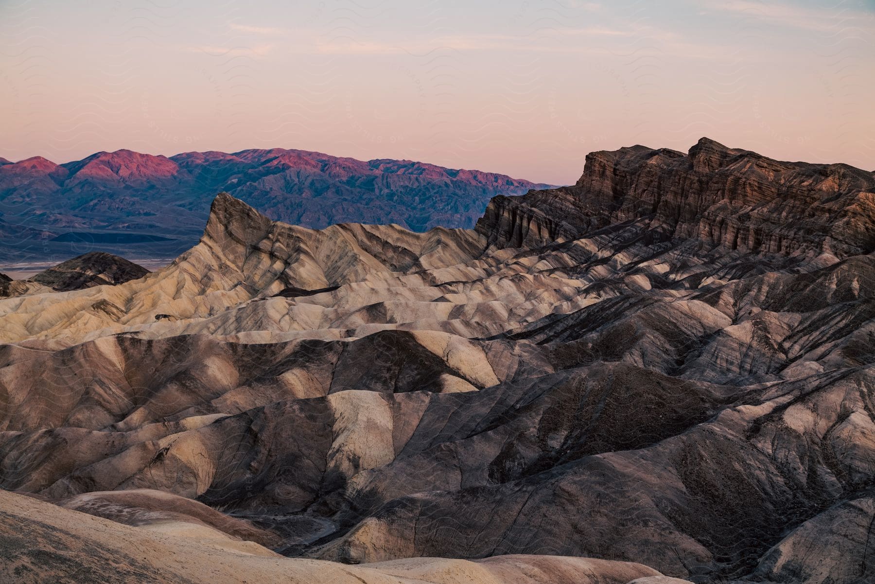 Sun setting over mountainous horizon