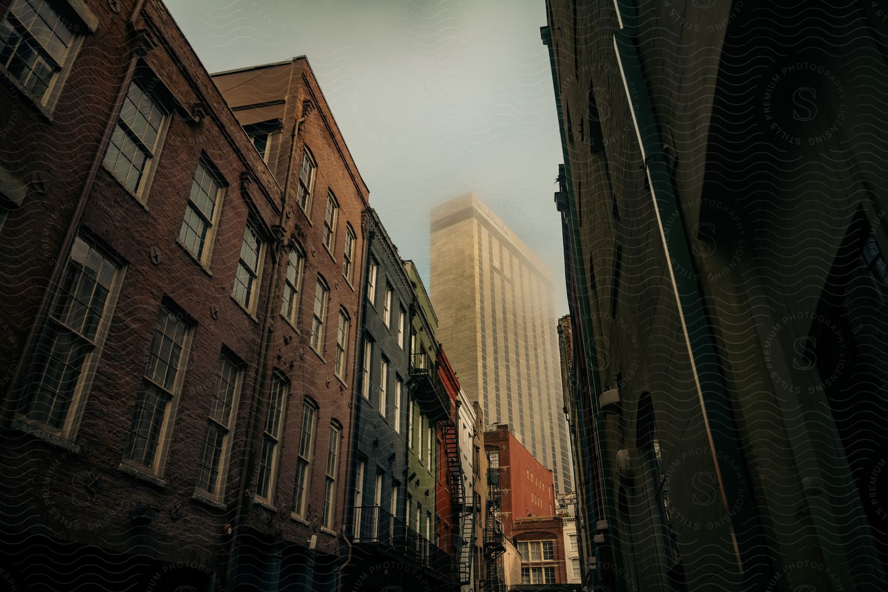 A skyscraper in the city is covered in fog during the morning