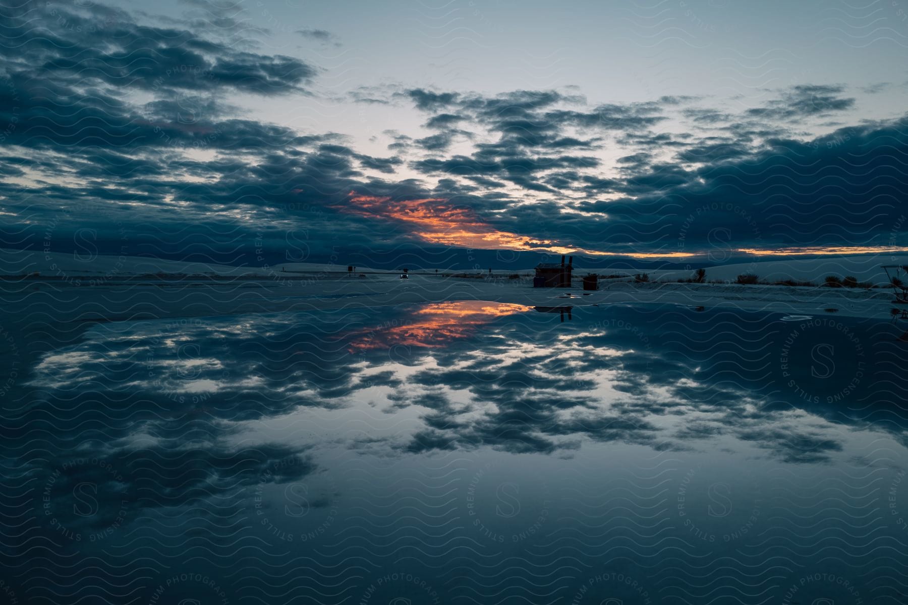 A serene lakeside at dusk with beautiful clouds and a calm atmosphere