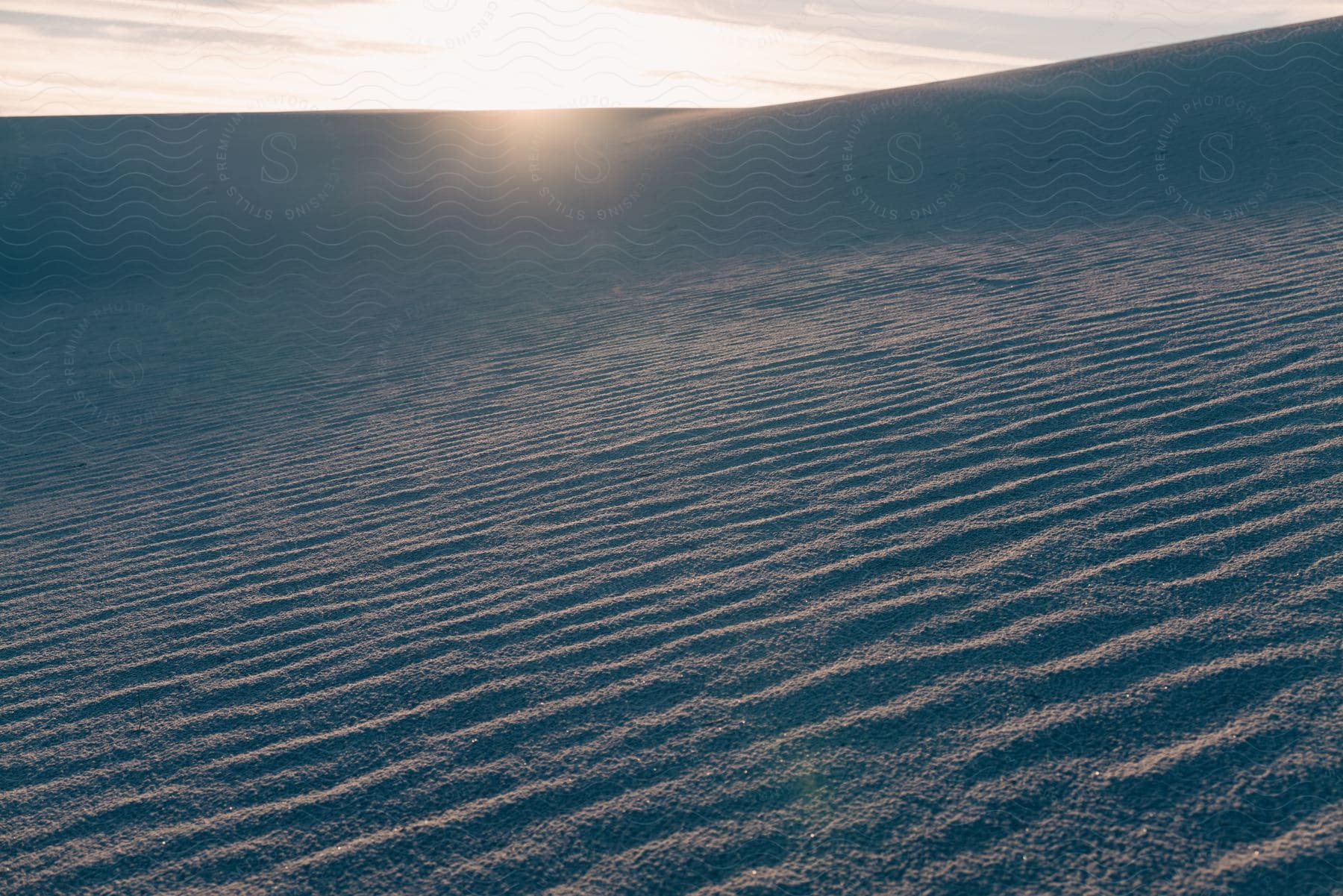 A sunset over a landscape with a sloping ground and neutral atmosphere