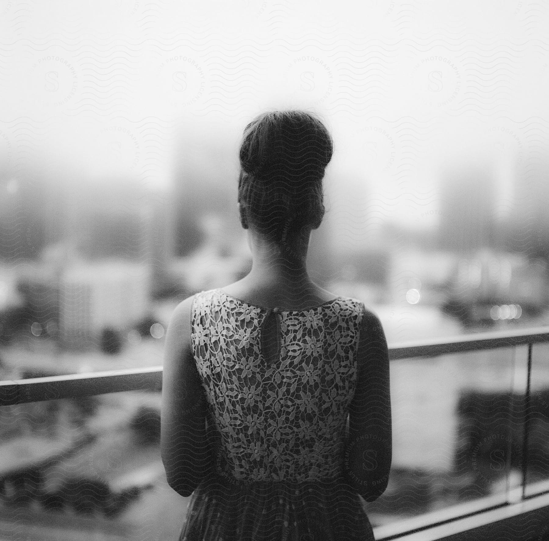 Woman wearing vintage outfit and hairstyle looking at city from balcony