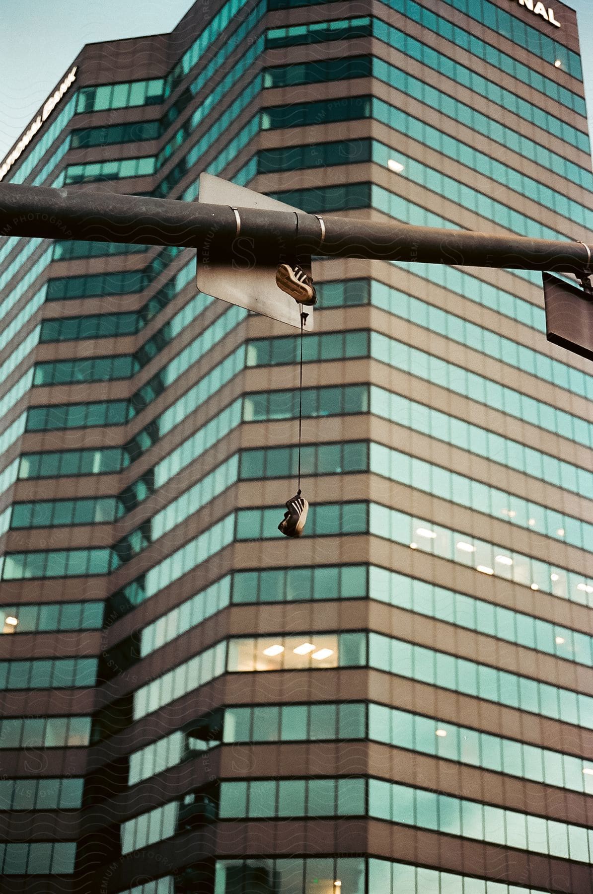 Shoes hanging on a traffic light beam in front of a skyscraper