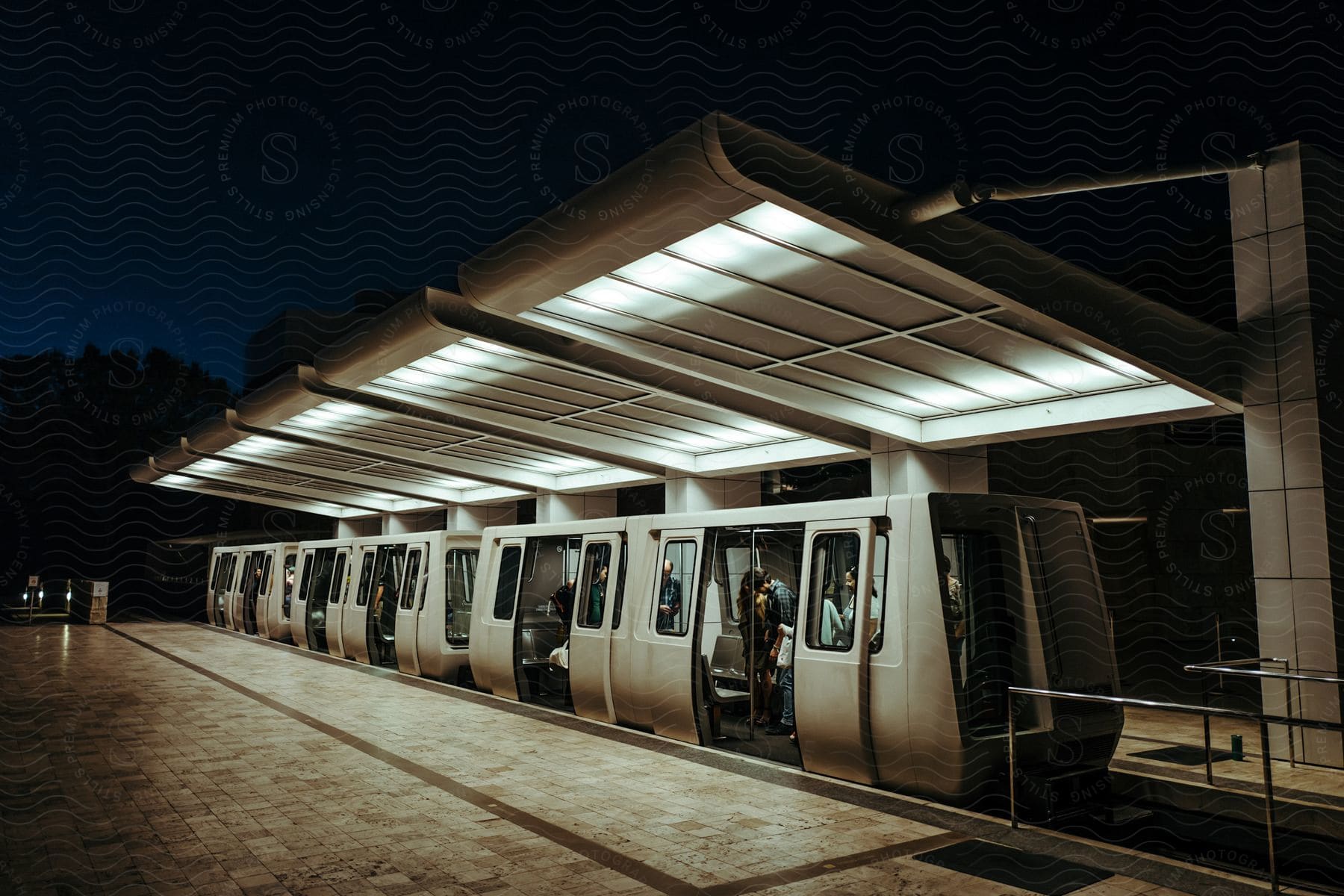 A small train filled with passengers at a railway station