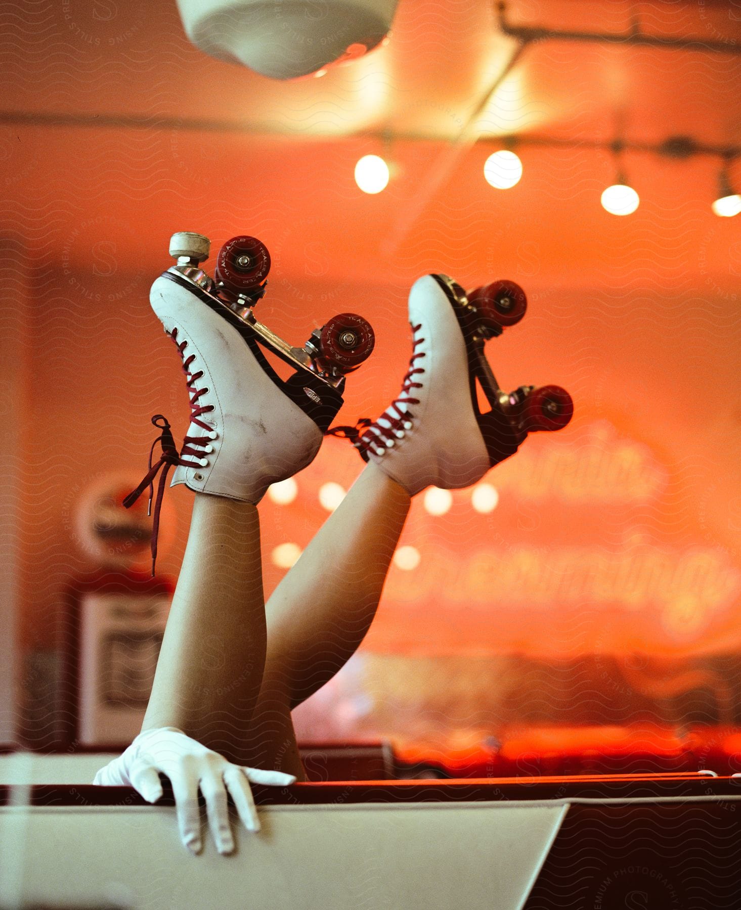 Reclining woman in vintage diner chair wearing white glove and roller shoe