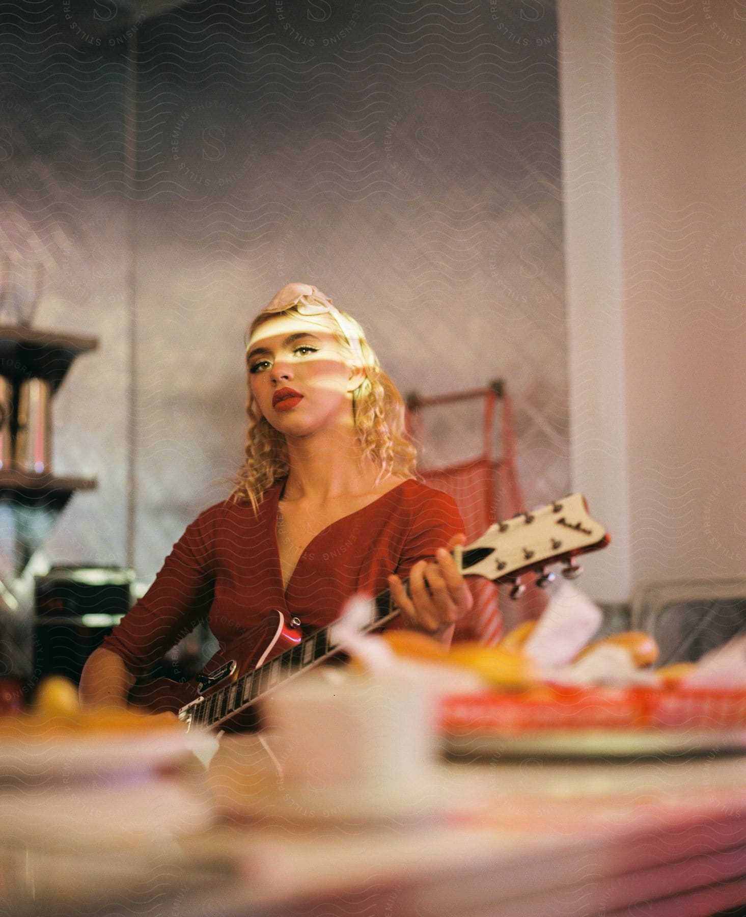 A woman sits at a table and holds a guitar in a vintage diner in downtown la