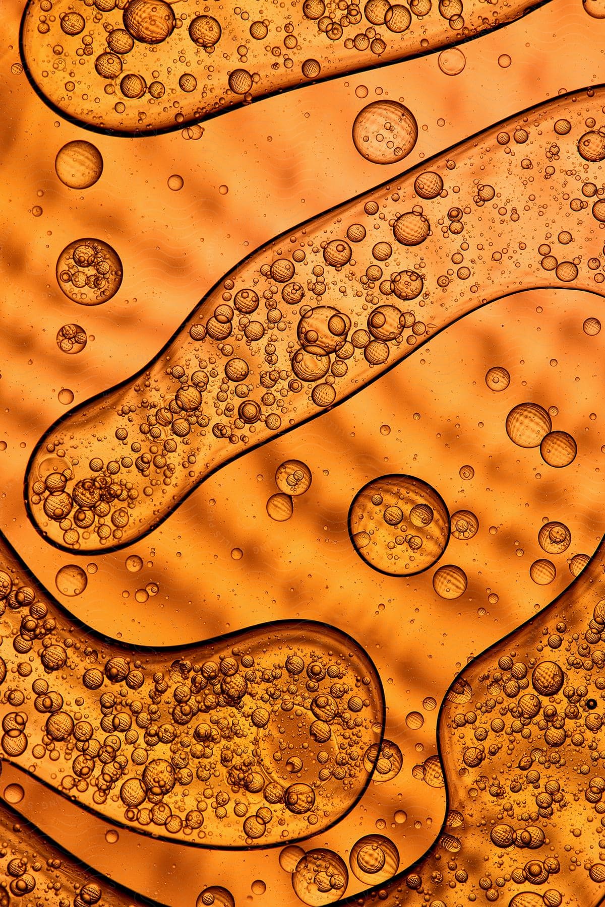 Bubbling liquid spread over a transparent glass surface in closeup view