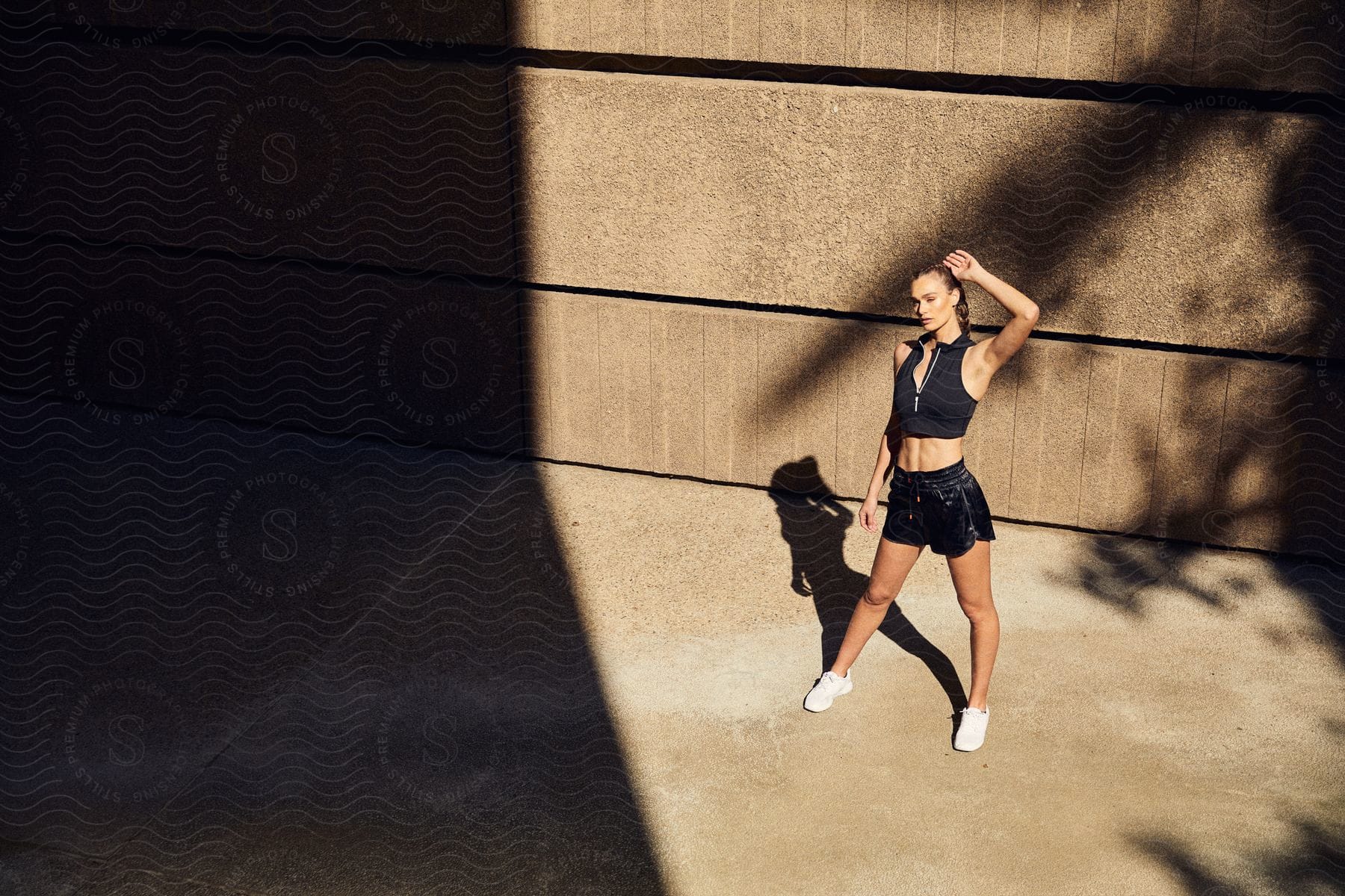 A female model posing on a city sidewalk wearing shorts