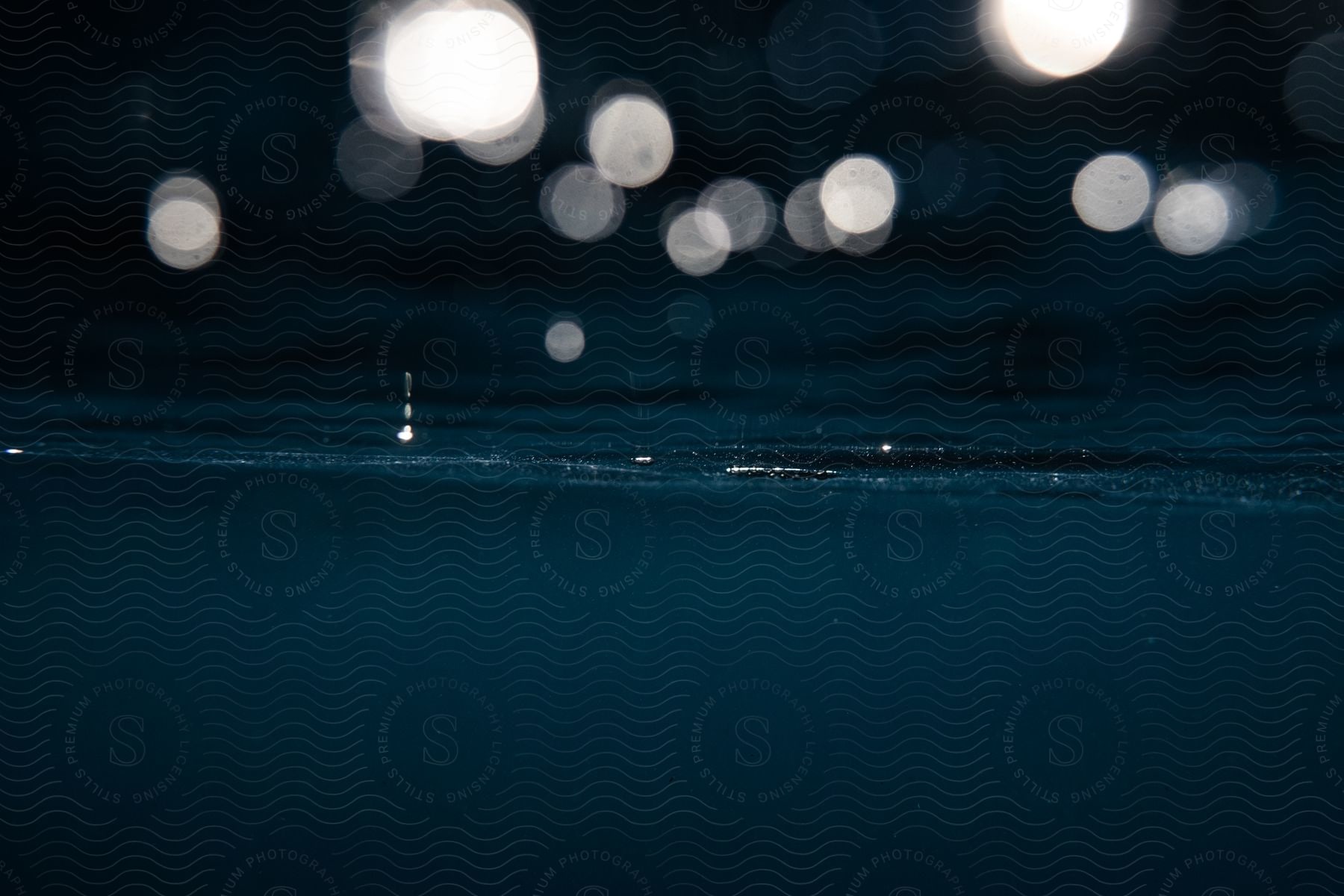 The underside of water surface at night showing abstract shapes and textures