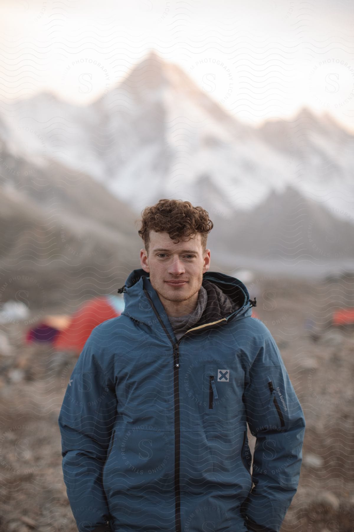 Man posing for a photo wearing a winter coat in a mountain landscape