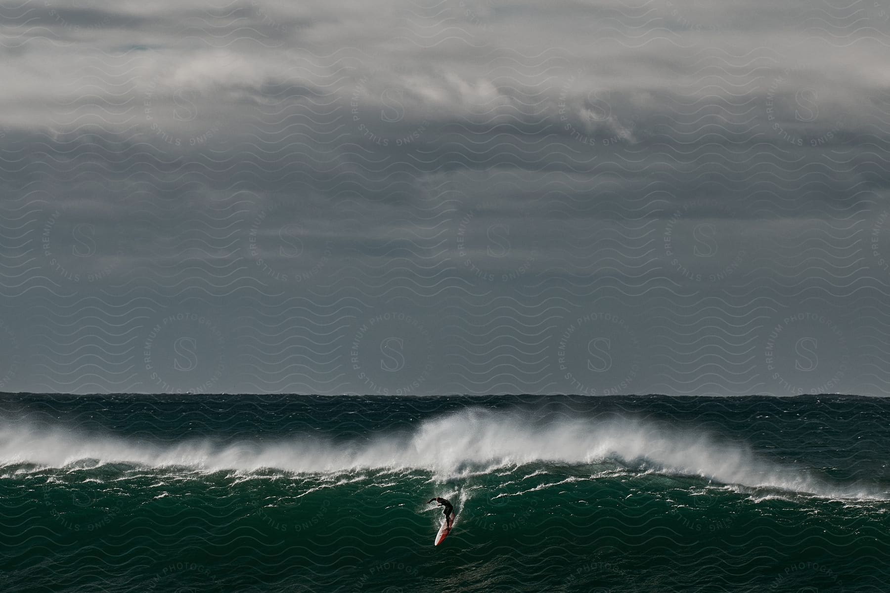 A person surfing on ocean waves during a cloudy day