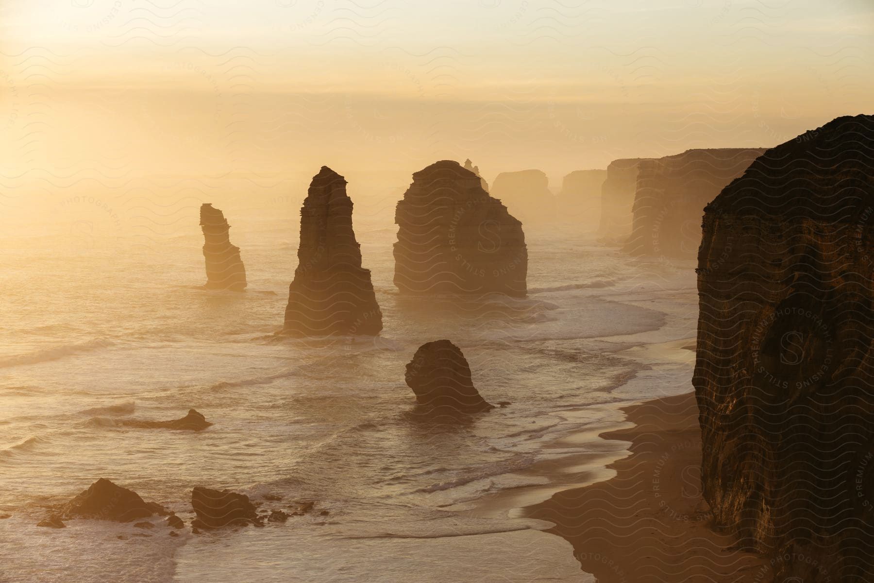 The sun is setting on the coast of the beach at dusk