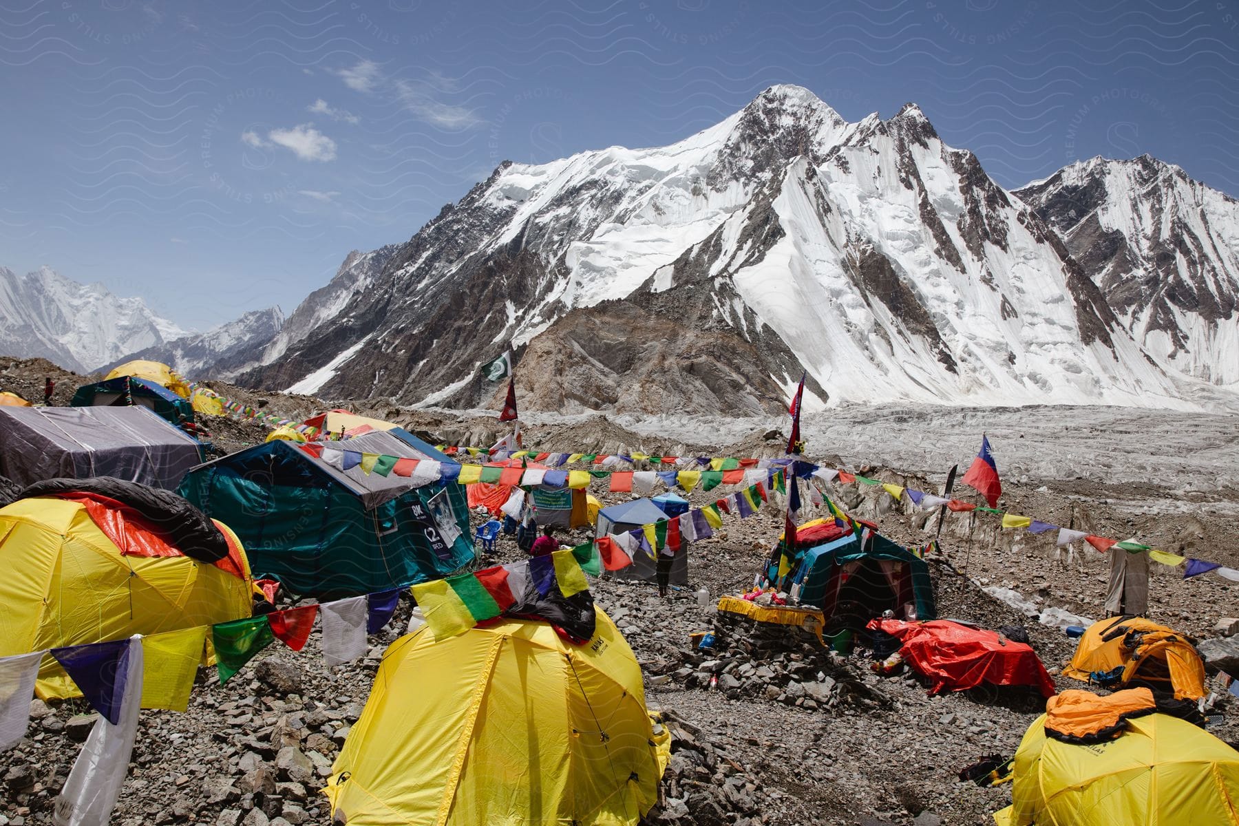 Several tents at the base of a snowcovered mountain daytime