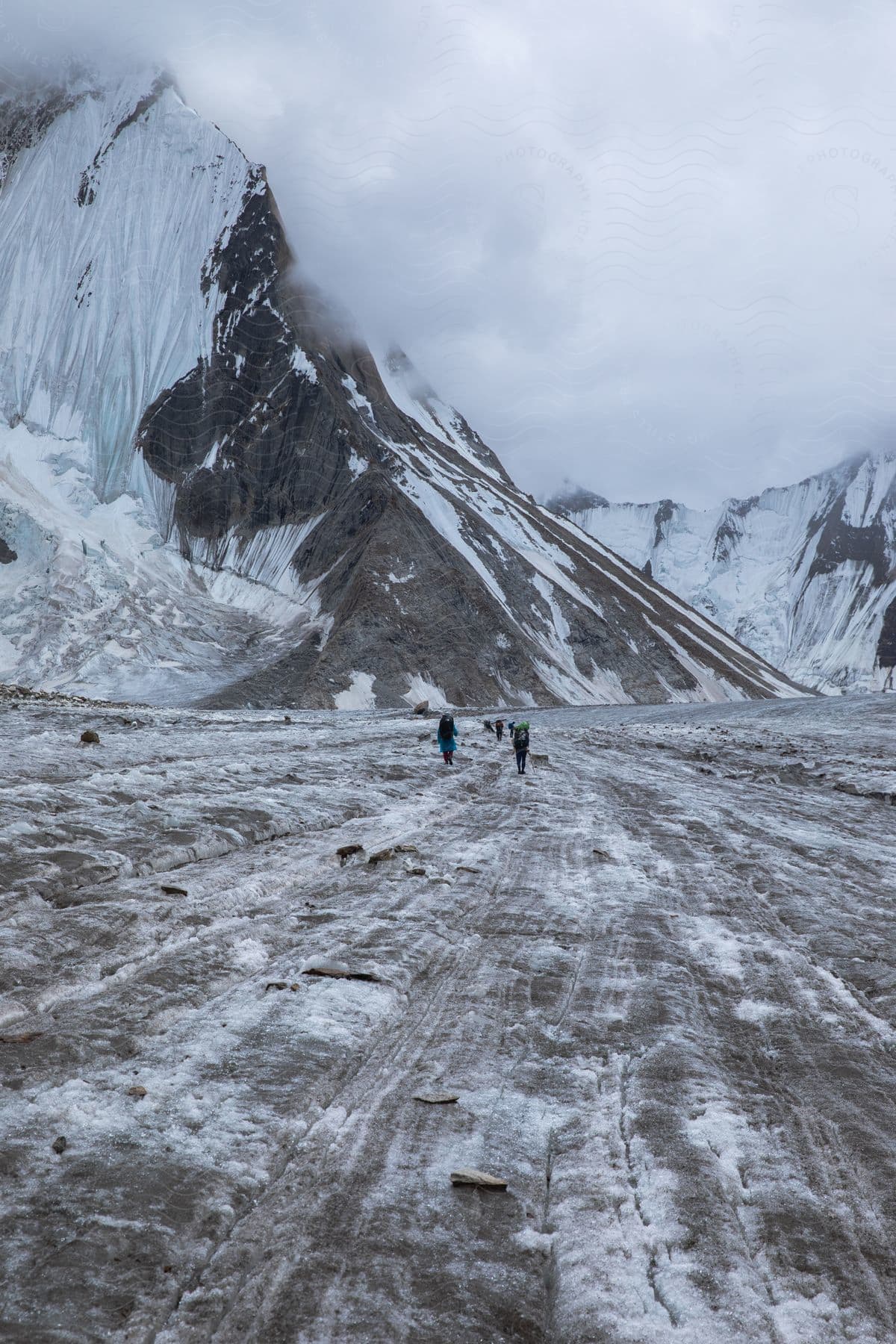 A group of people walking near a mountain in winter