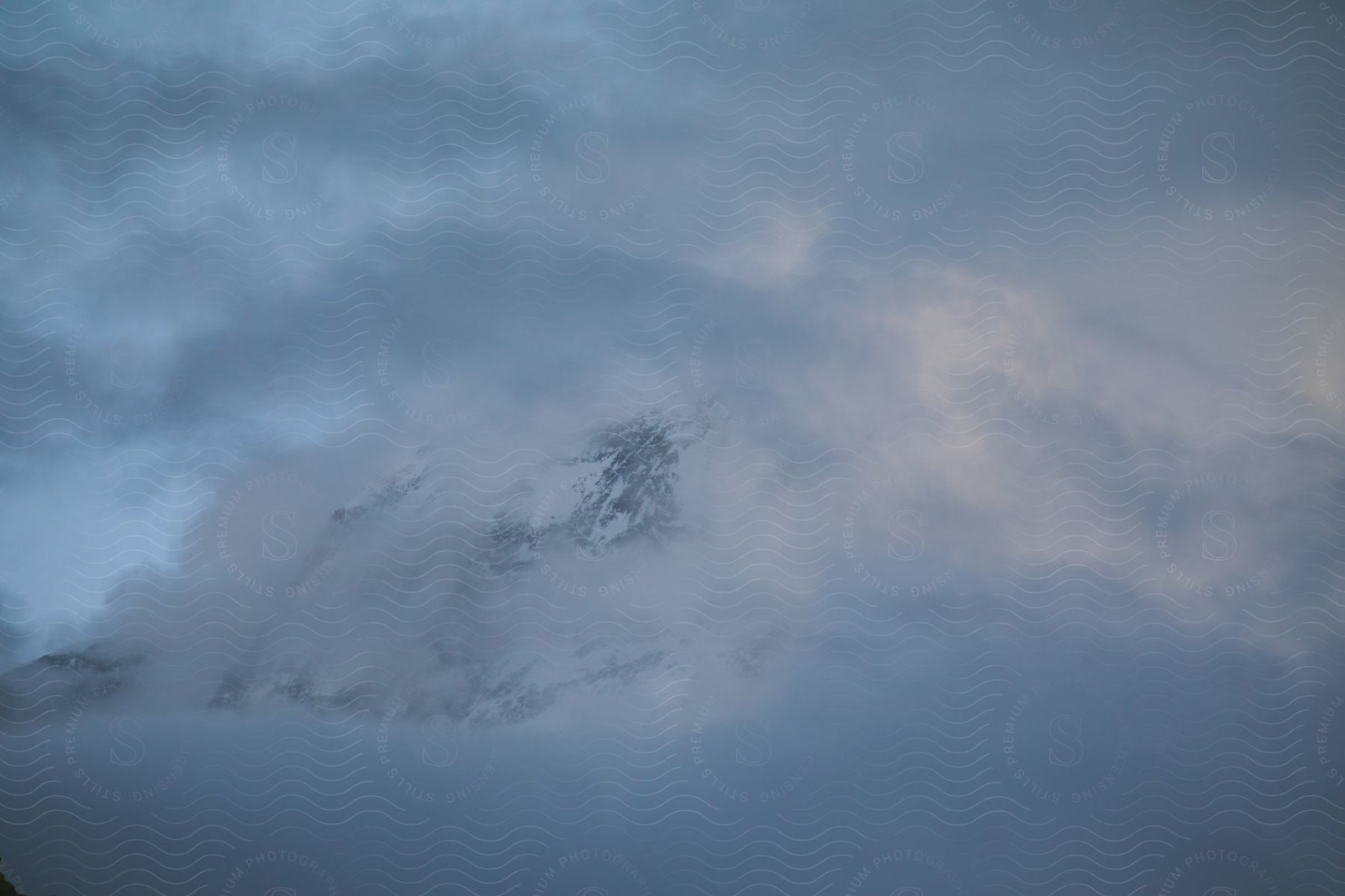 Snowcovered mountain surrounded by fog and chilling wintry atmosphere