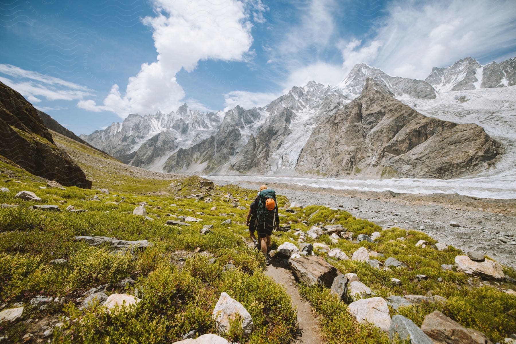 Stock photo of a person hiking on a rugged trail through mountains and canyons