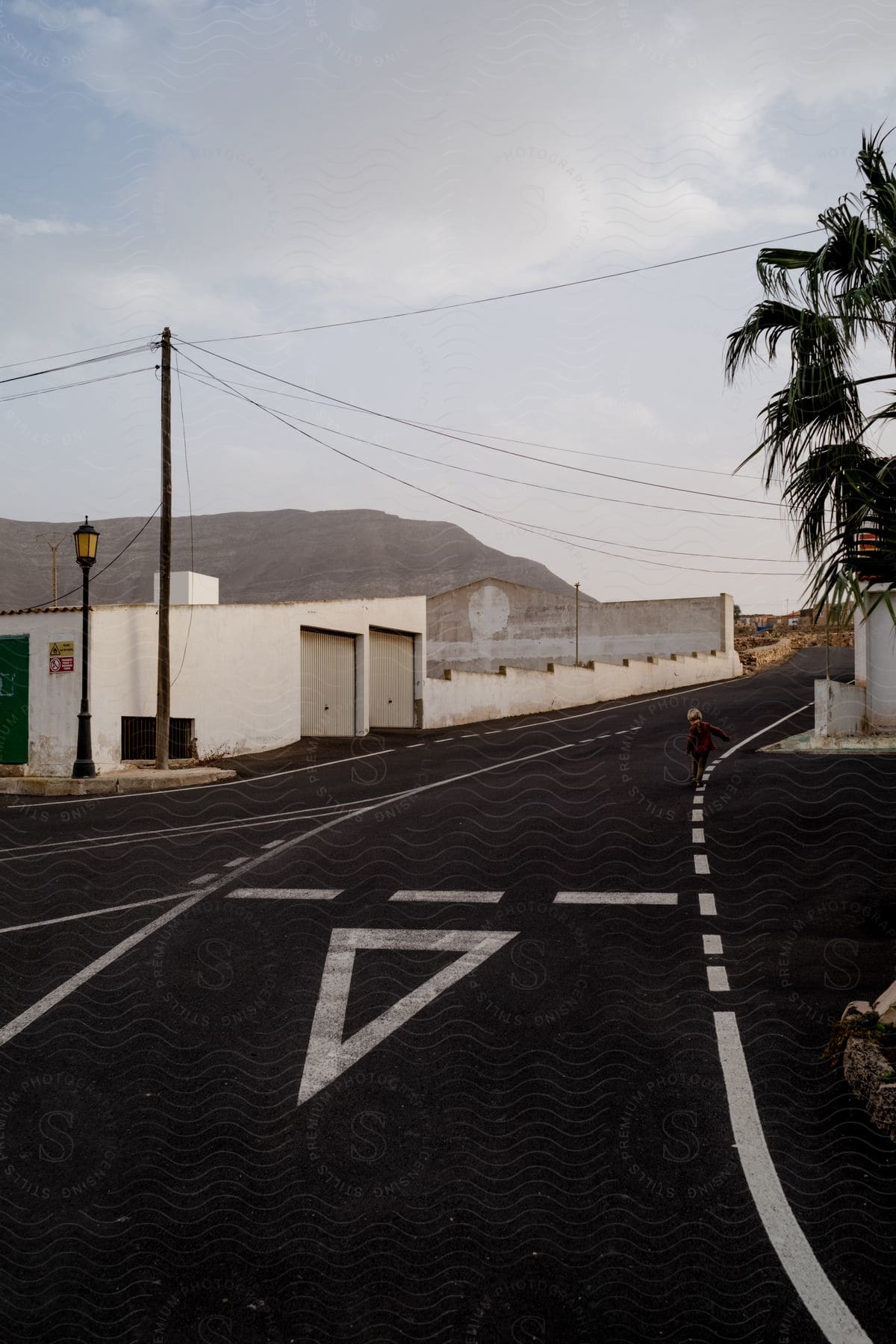 A person walking on a road line at a merging of roads in an urban residential area