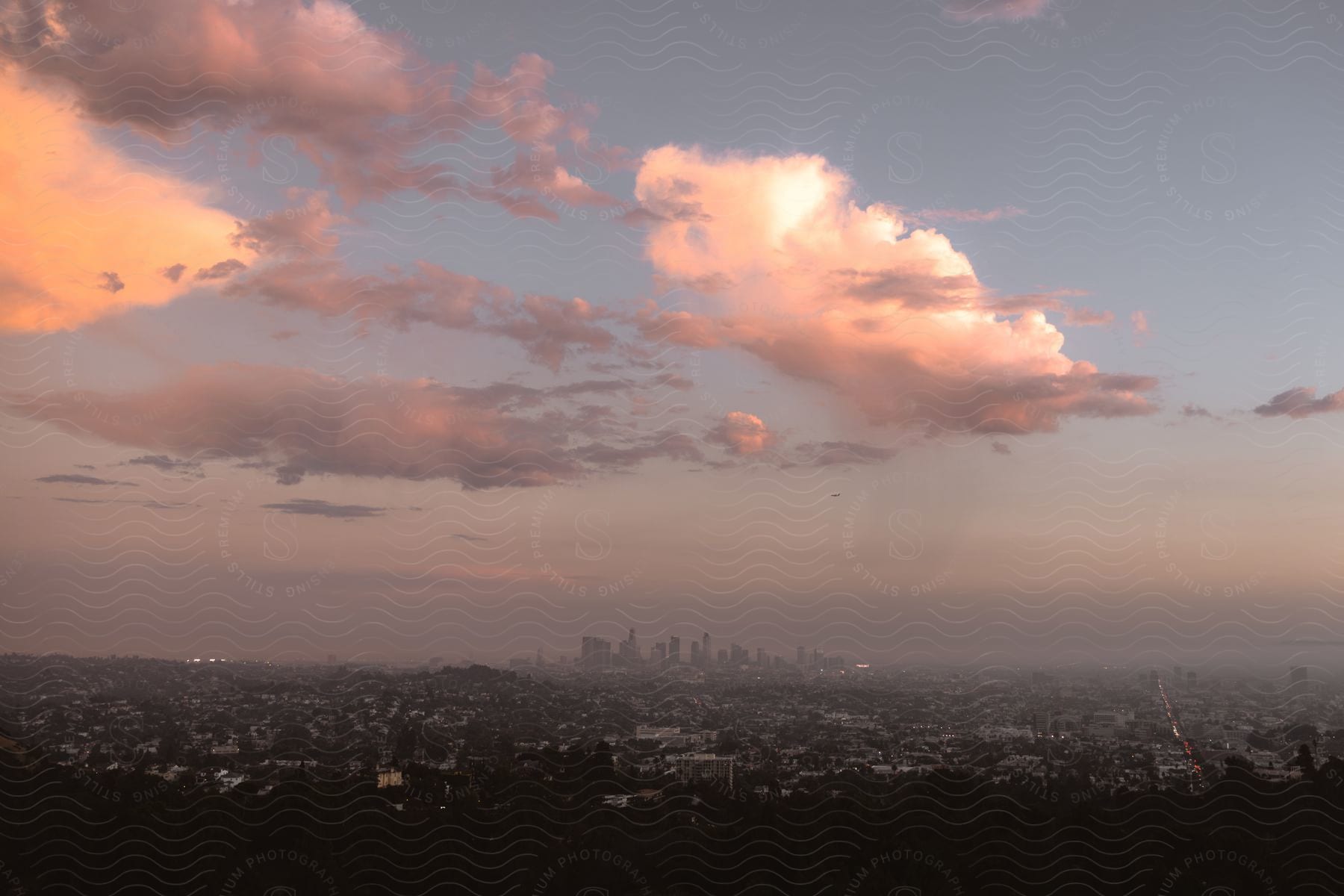 Aerial shot of the sun setting over a downtown city