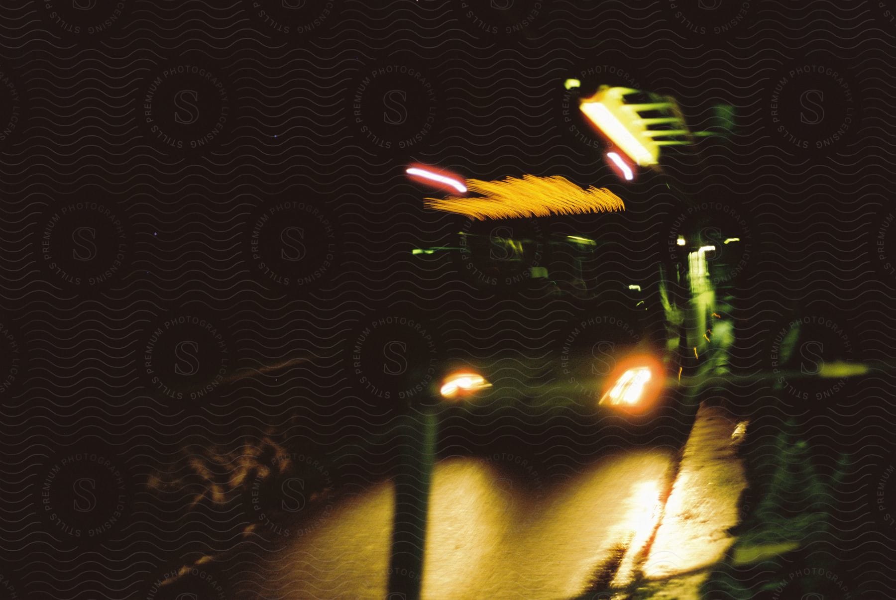 A sedan car driving at night on a dark road