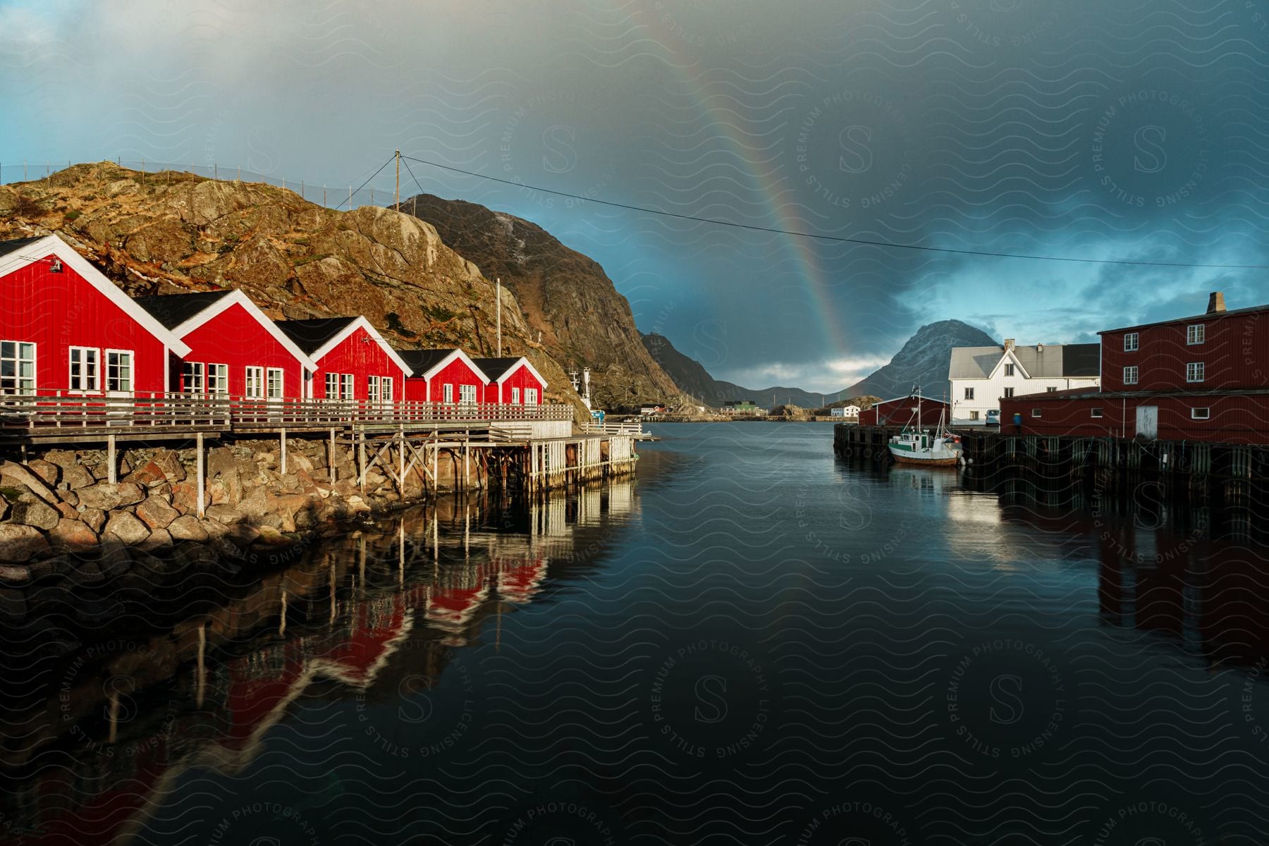 Coastal island with red houses mountains and rainbow on the horizon