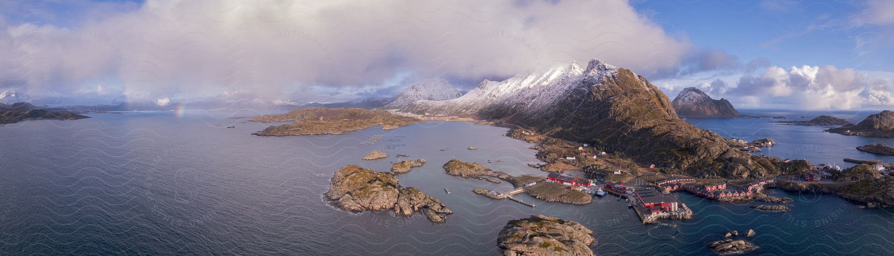 Snowcovered mountain overlooks village in lofoten norway