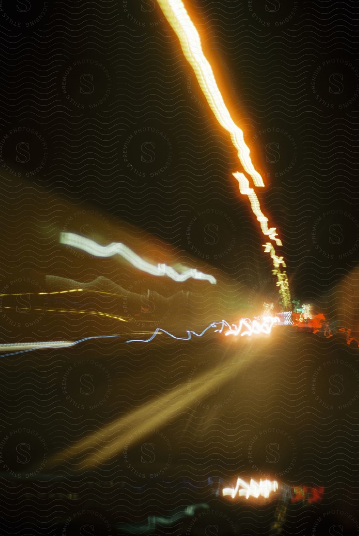 A road running through a tunnel at night with distorted car lights