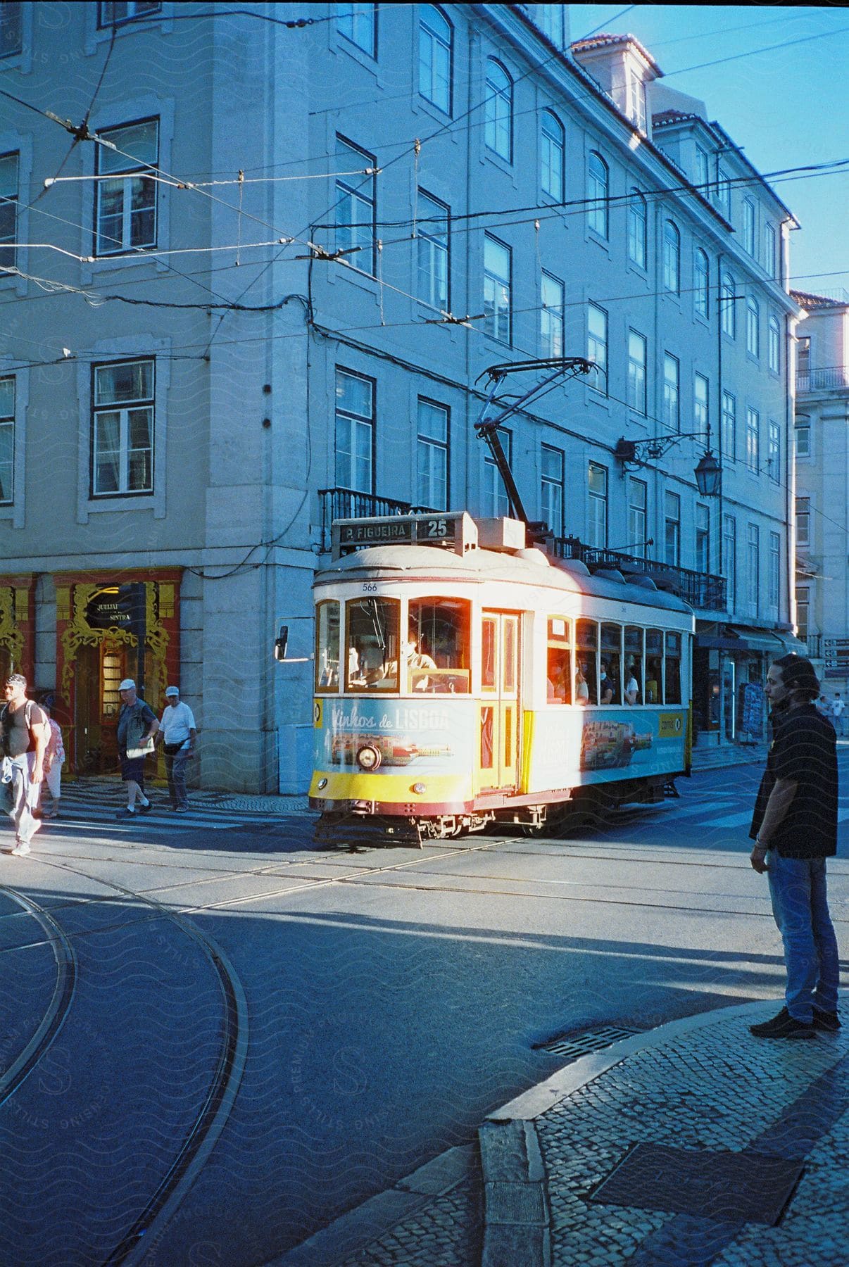 A trolley drives down a city street in lisbon portugal