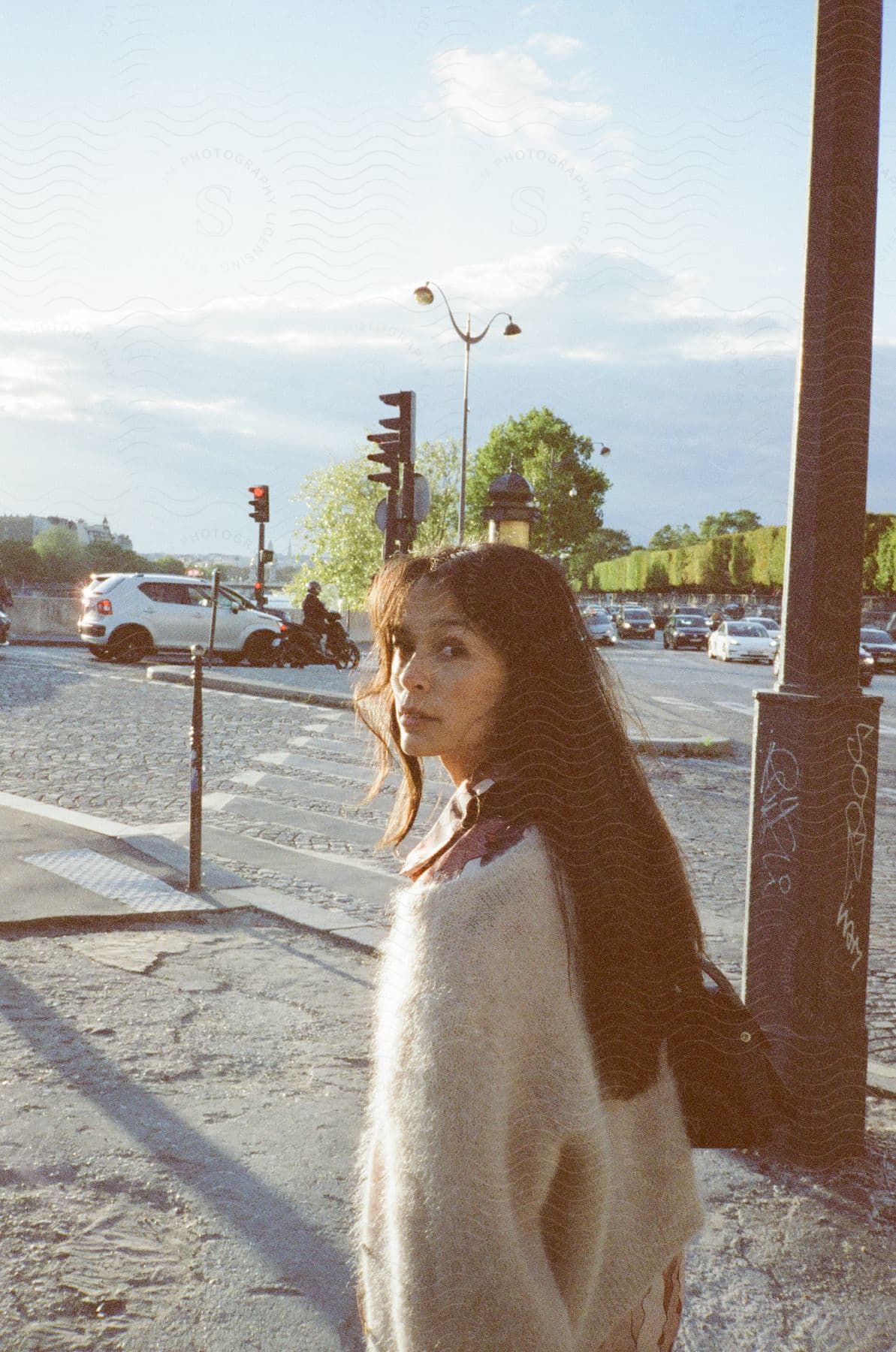 A woman walking down the street with traffic in the background