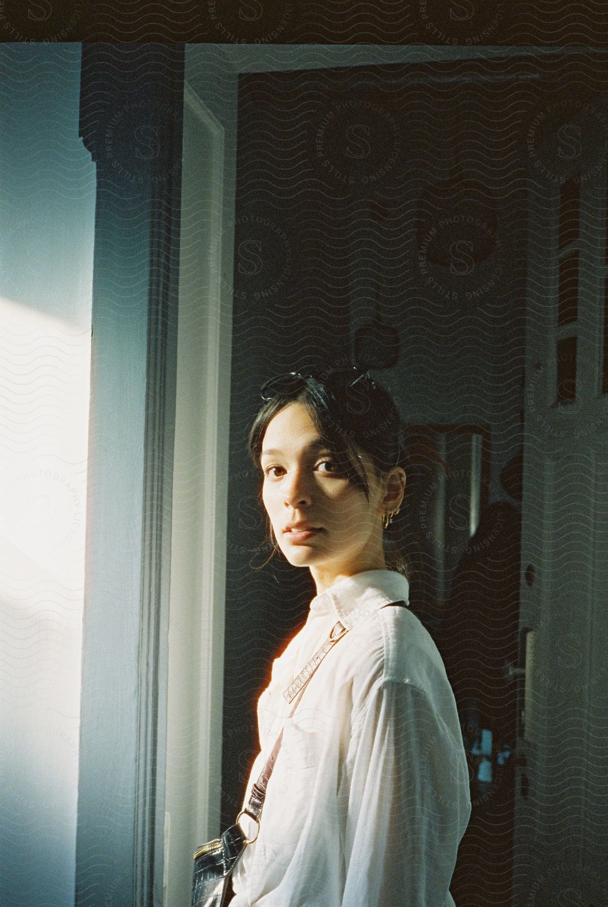 Woman standing in a doorway looking towards the viewer