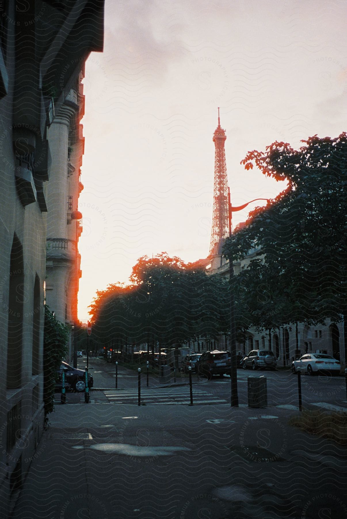 A cityscape at dusk with buildings roads and a sunset sky