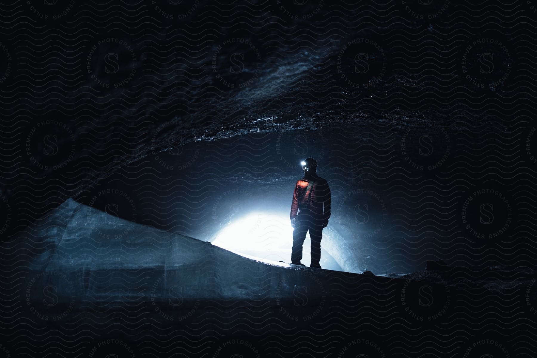 A person explores a cave during the daytime