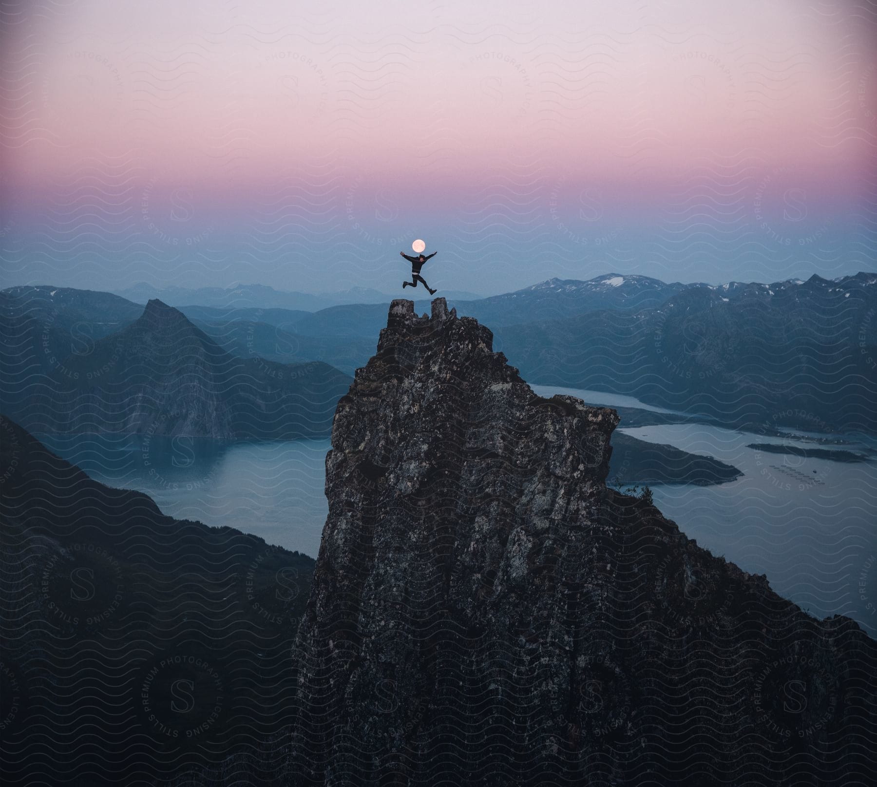 A person is jumping on top of a cliff outdoors