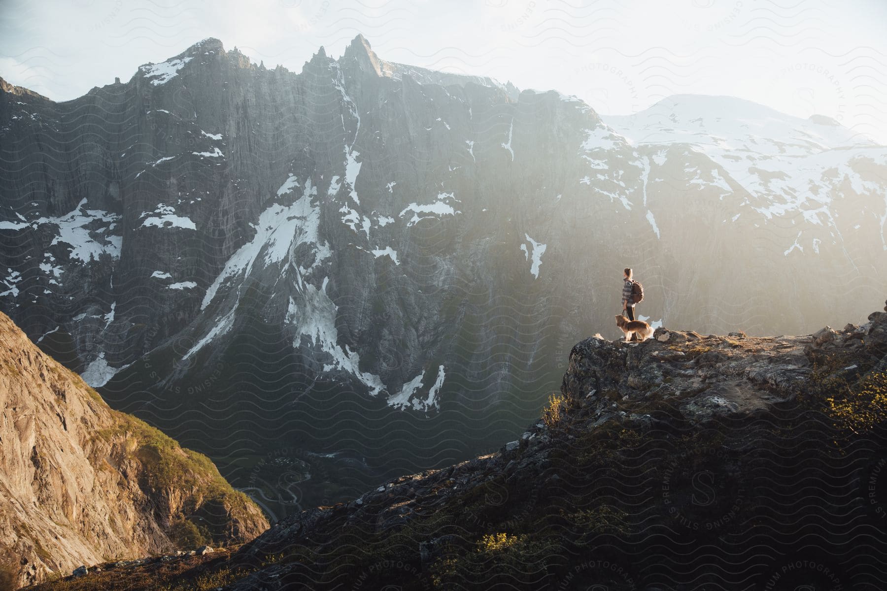 A person standing on a cliff in the norwegian wilderness