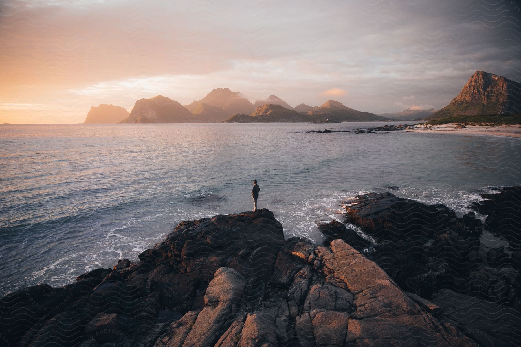 A person standing on a cliff overlooking the ocean