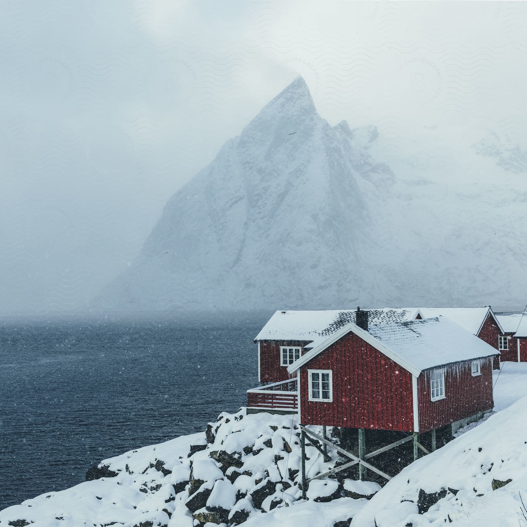 A winter scene in norway with mountains water and a house