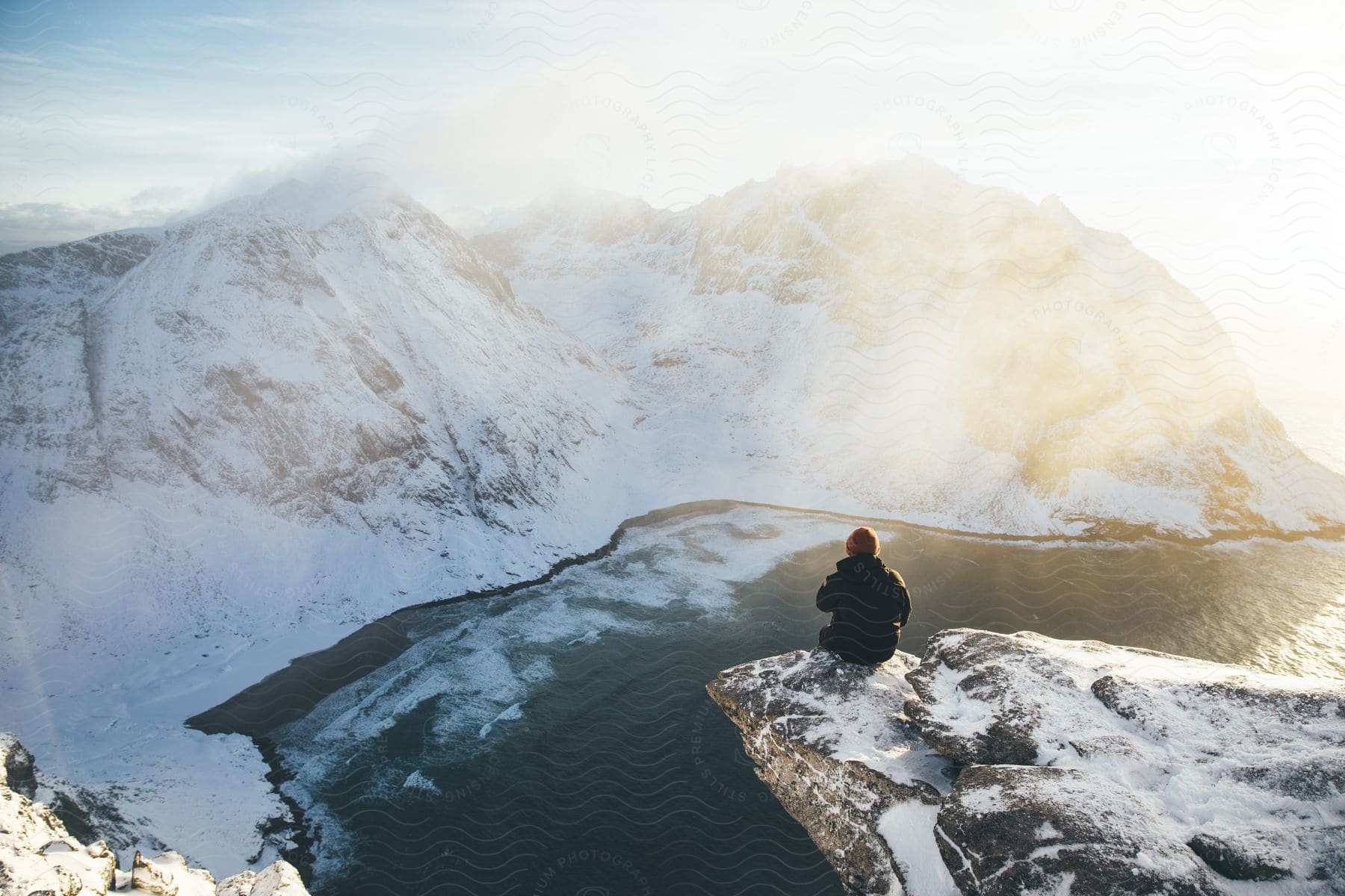 A person sitting on a cliff overlooking a scenic view