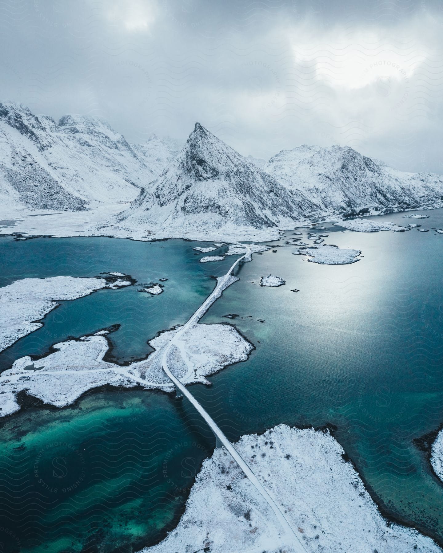 A frozen lake surrounded by snowcovered mountains and icy terrain