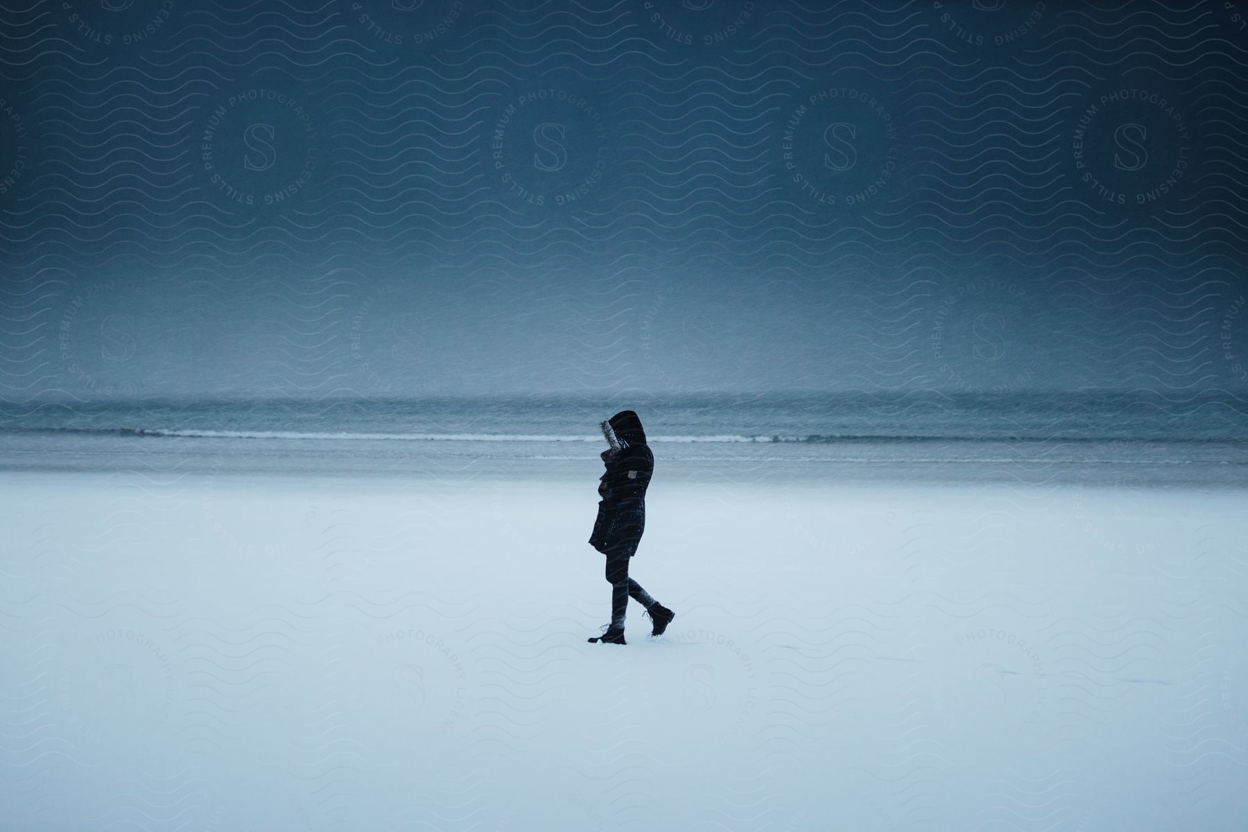 A person walking on the beach in winter