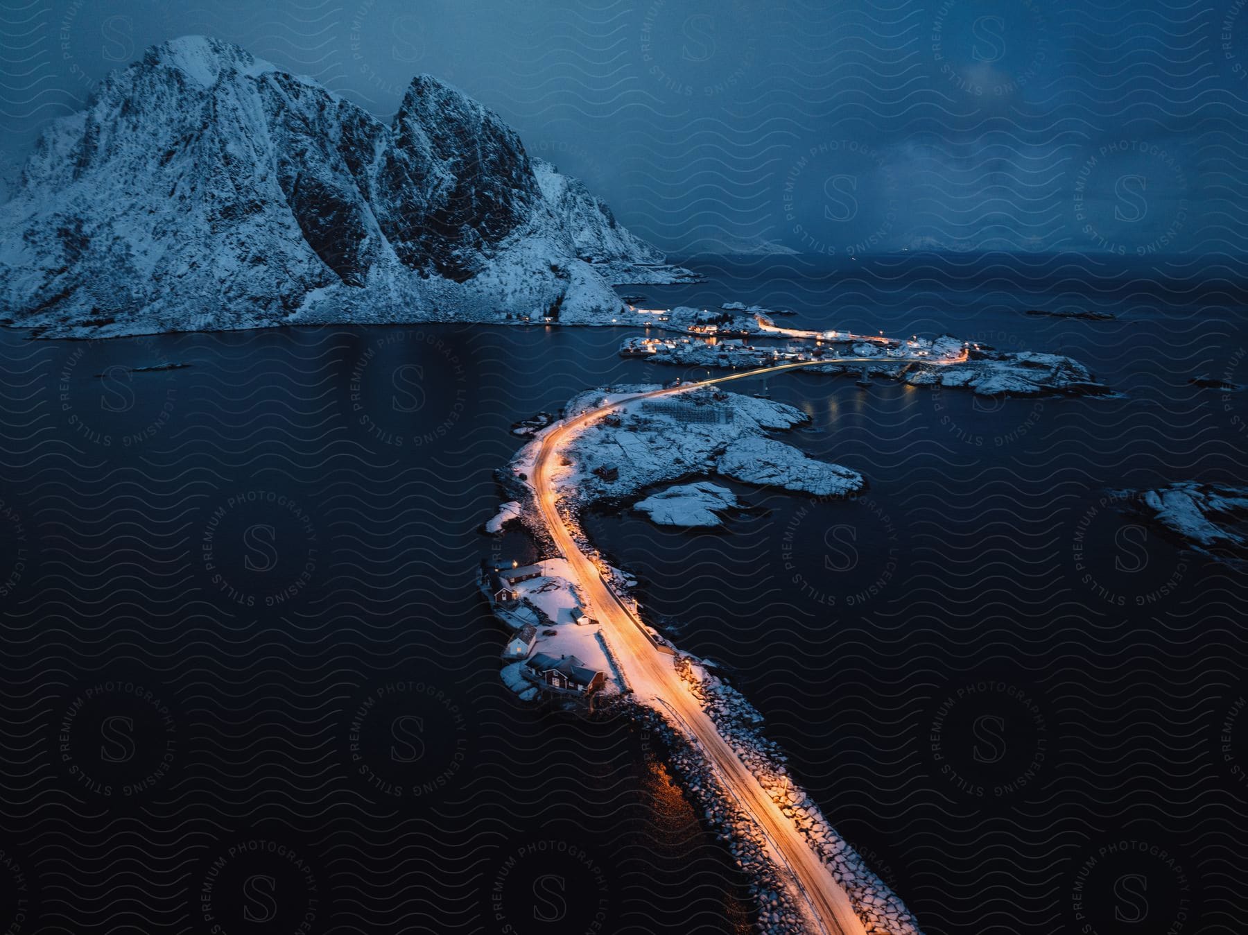 A road winds through small islands on the sea at night