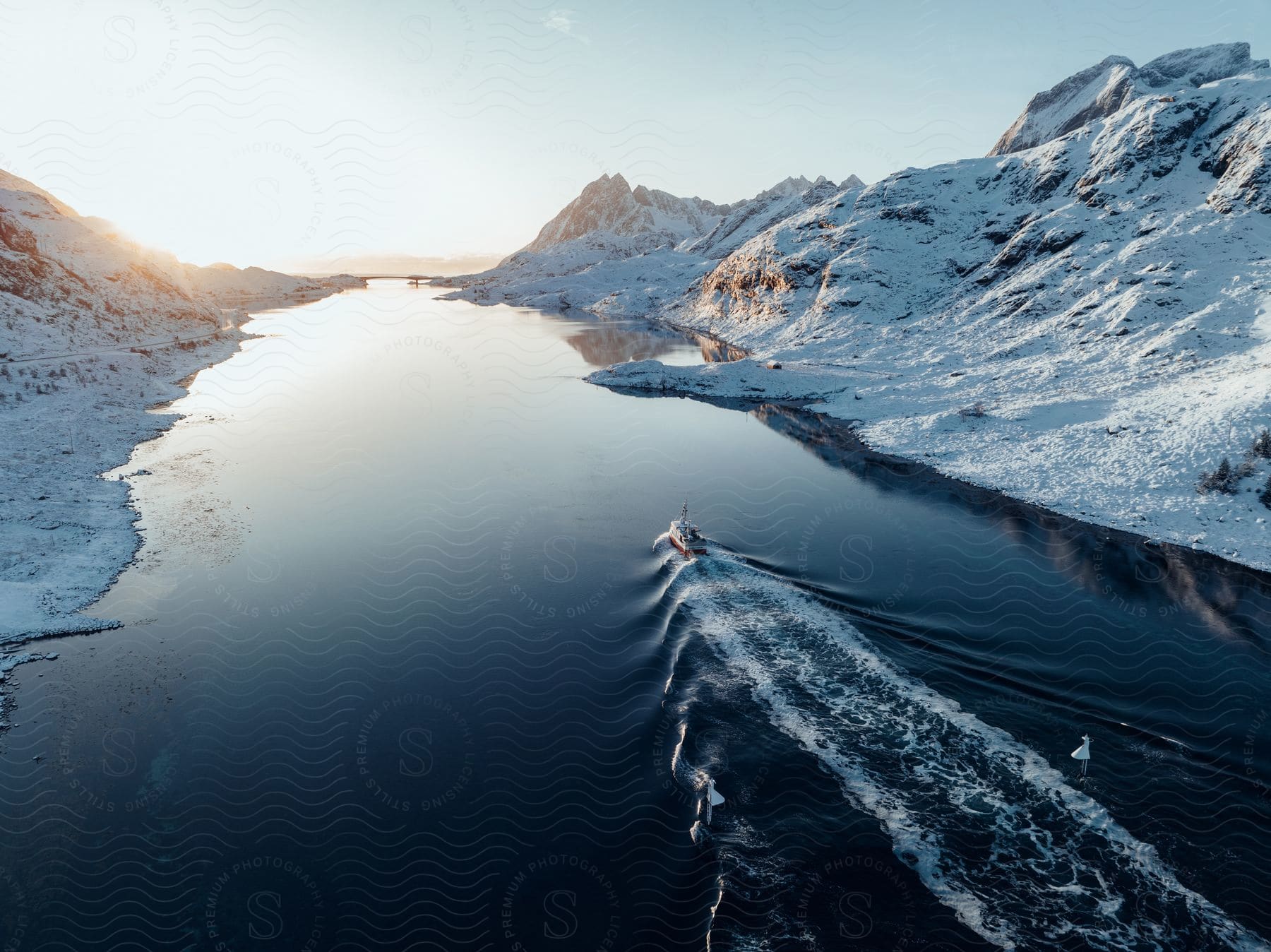 A serene winter landscape with a snowcovered mountain a frozen lake and a river flowing through the scene