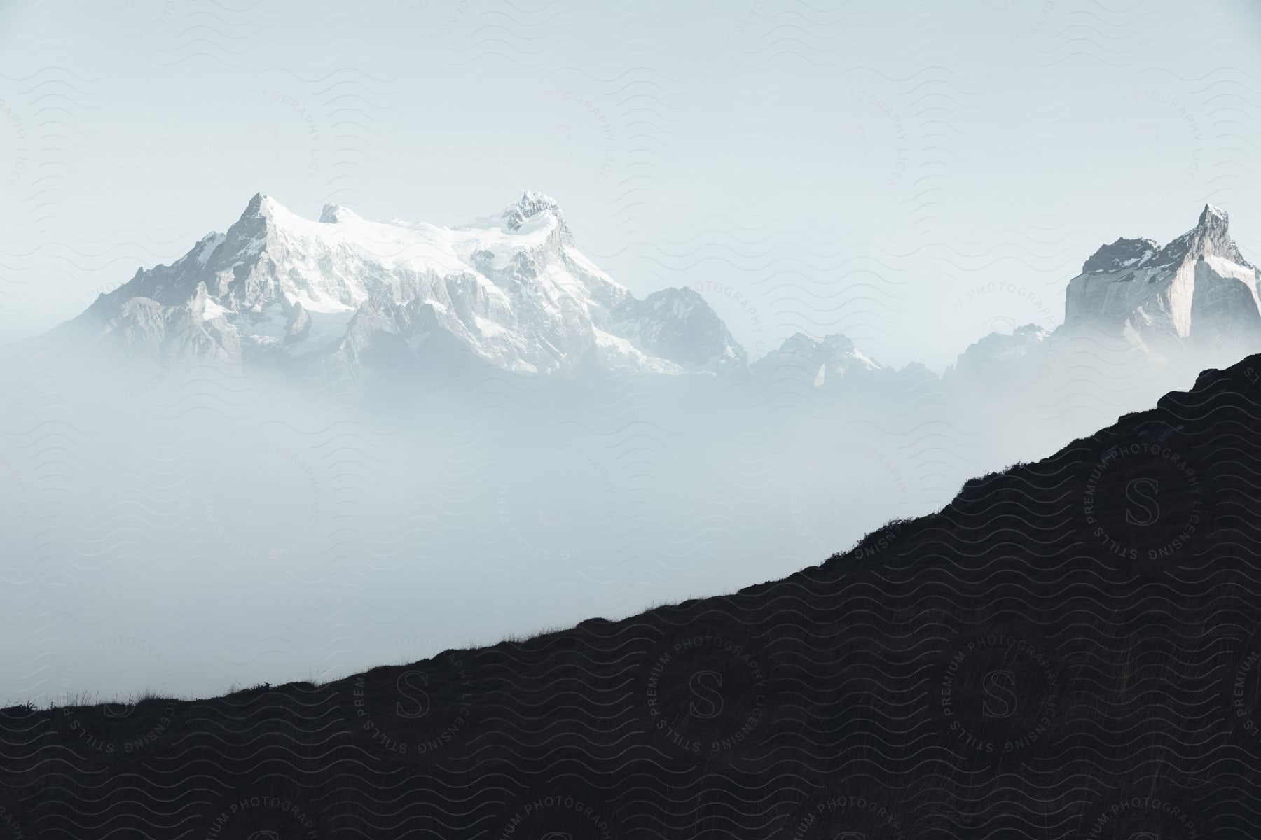 Snowcovered mountains seen through fog on a mountain slope