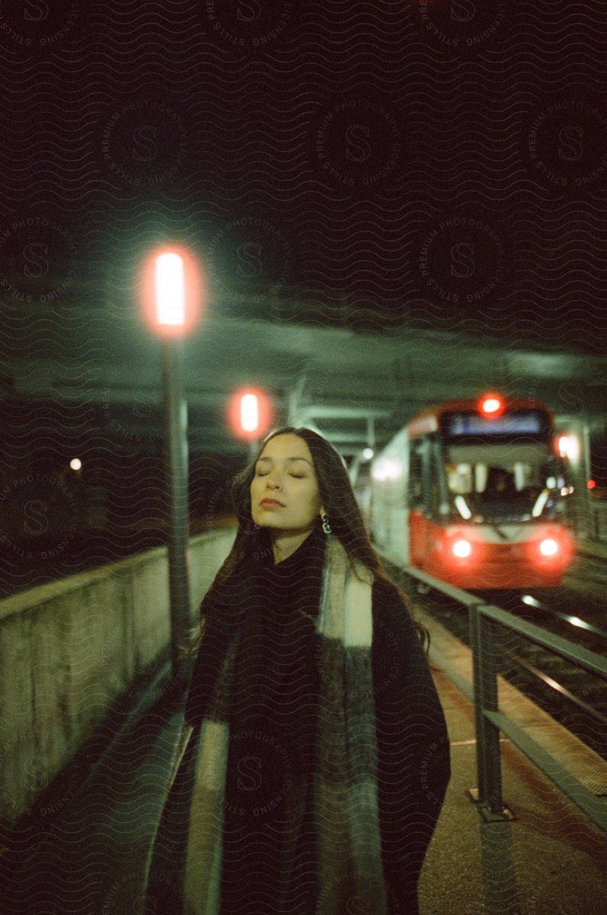 A woman stands next to a train at night