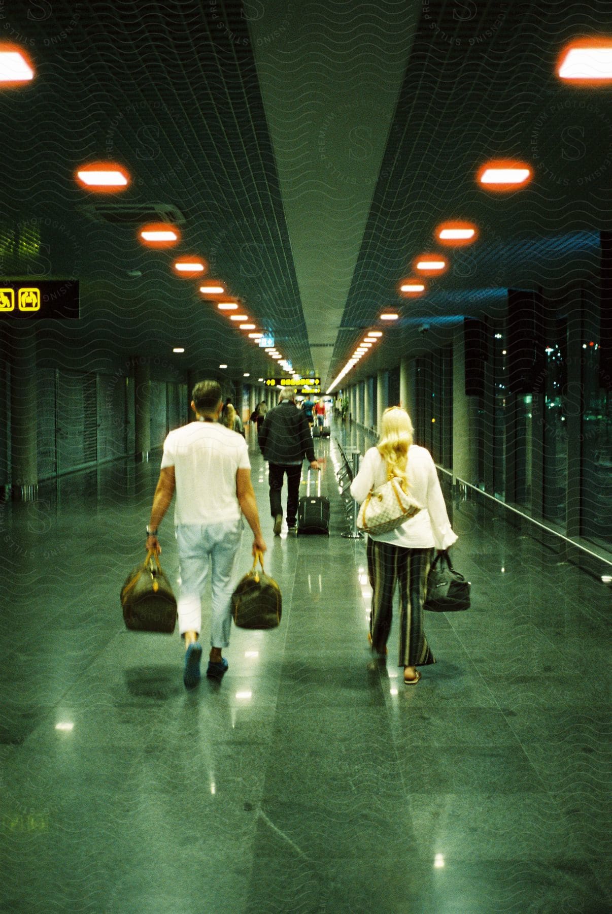 People with luggage walking in an airport corridor